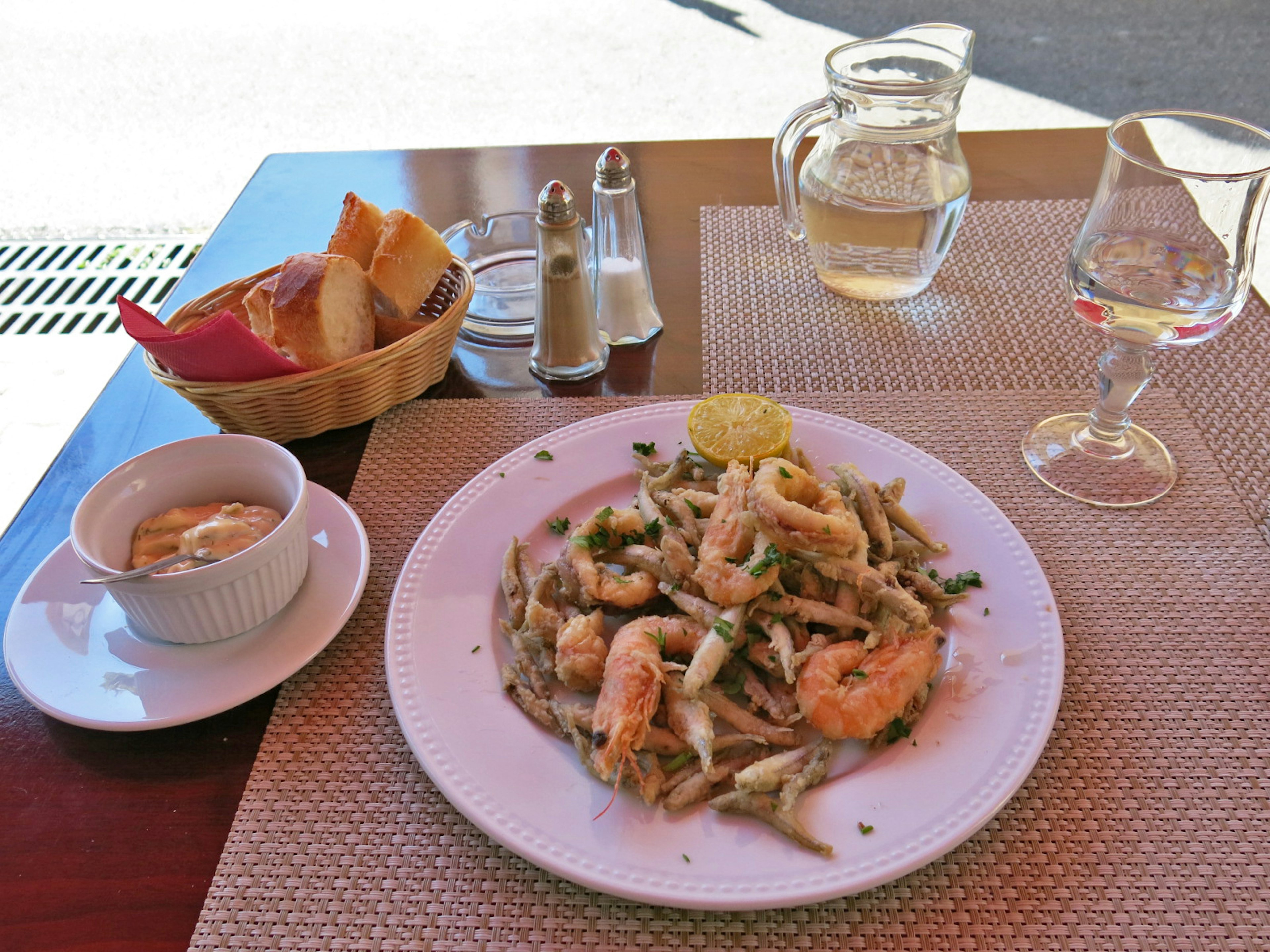 Teller mit Pasta und Garnelen sowie einer Schüssel Suppe auf einem Tisch