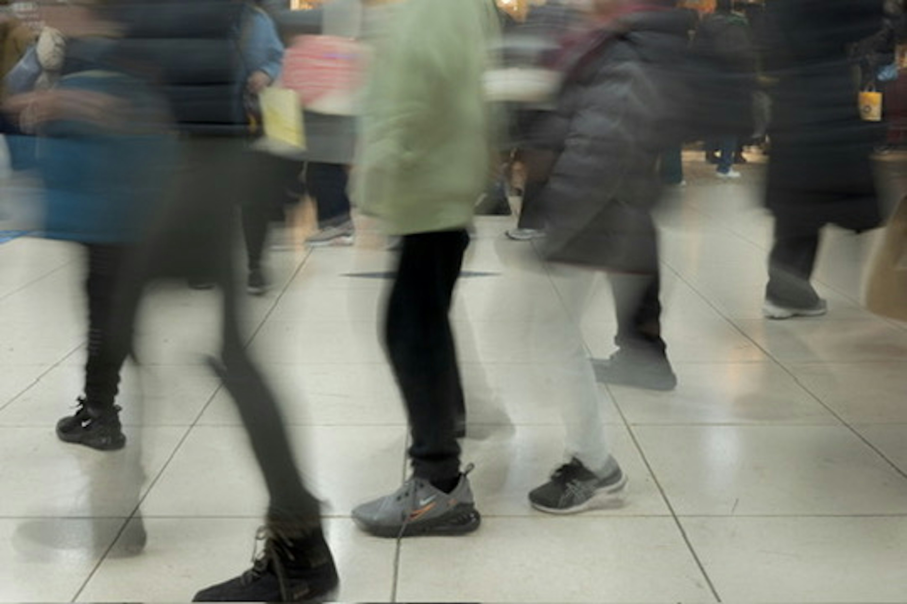 Pies borrosos de personas caminando en una estación ocupada