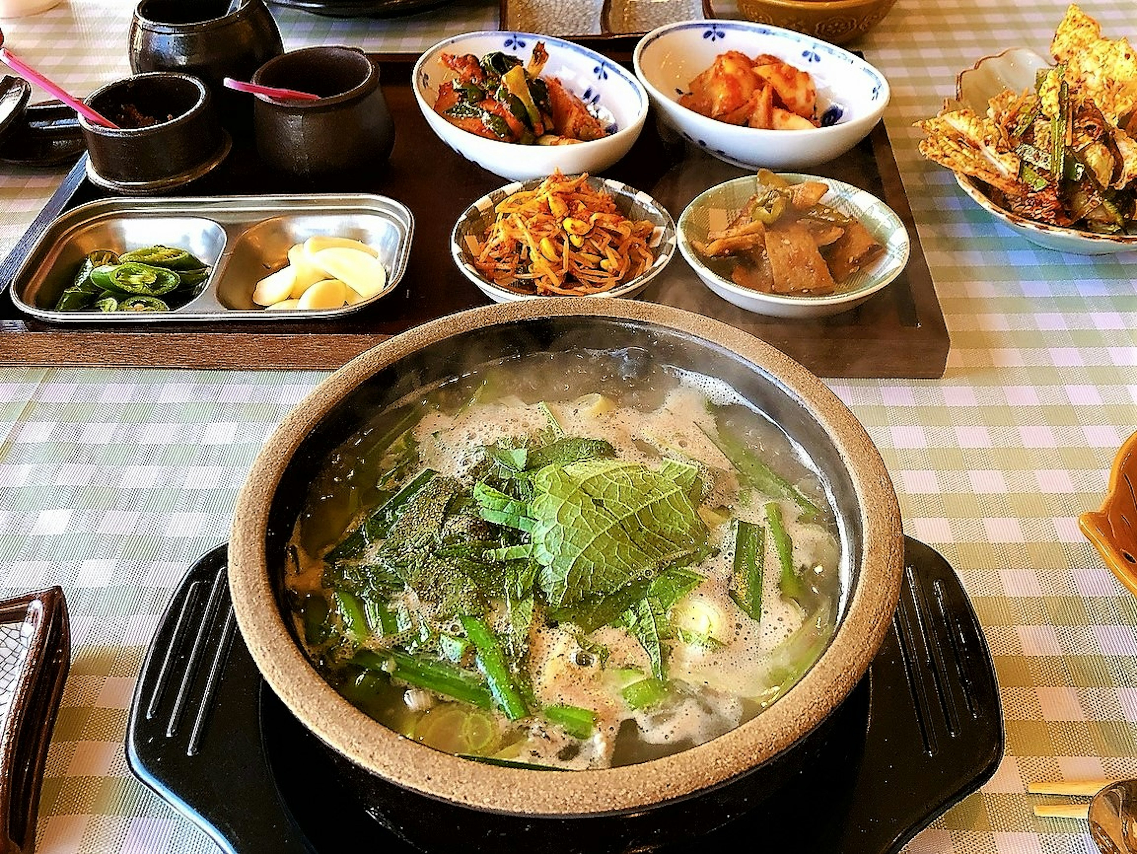 Plato de olla caliente con varios acompañamientos en la mesa