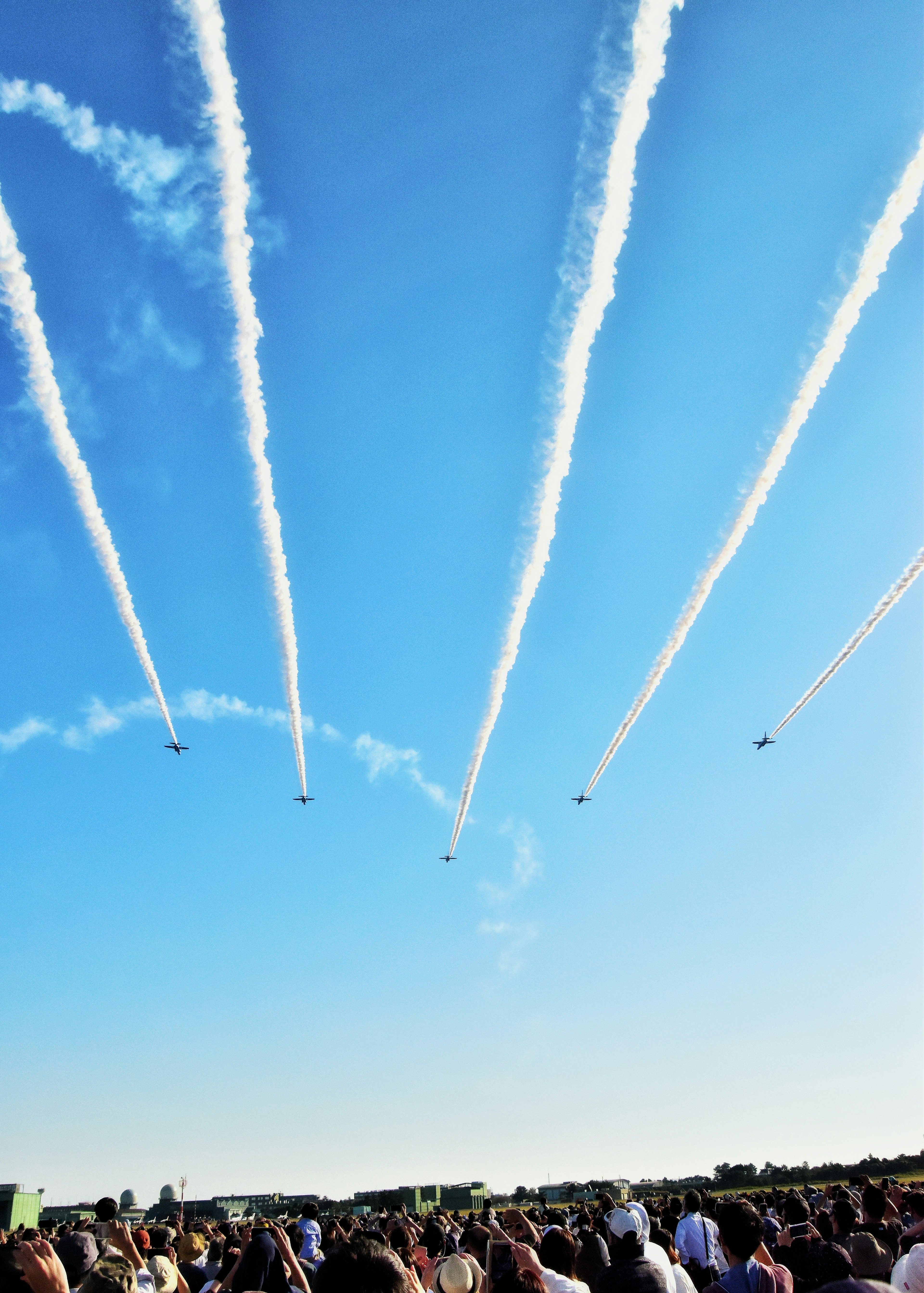 Spettacolo aereo con scie bianche nel cielo blu