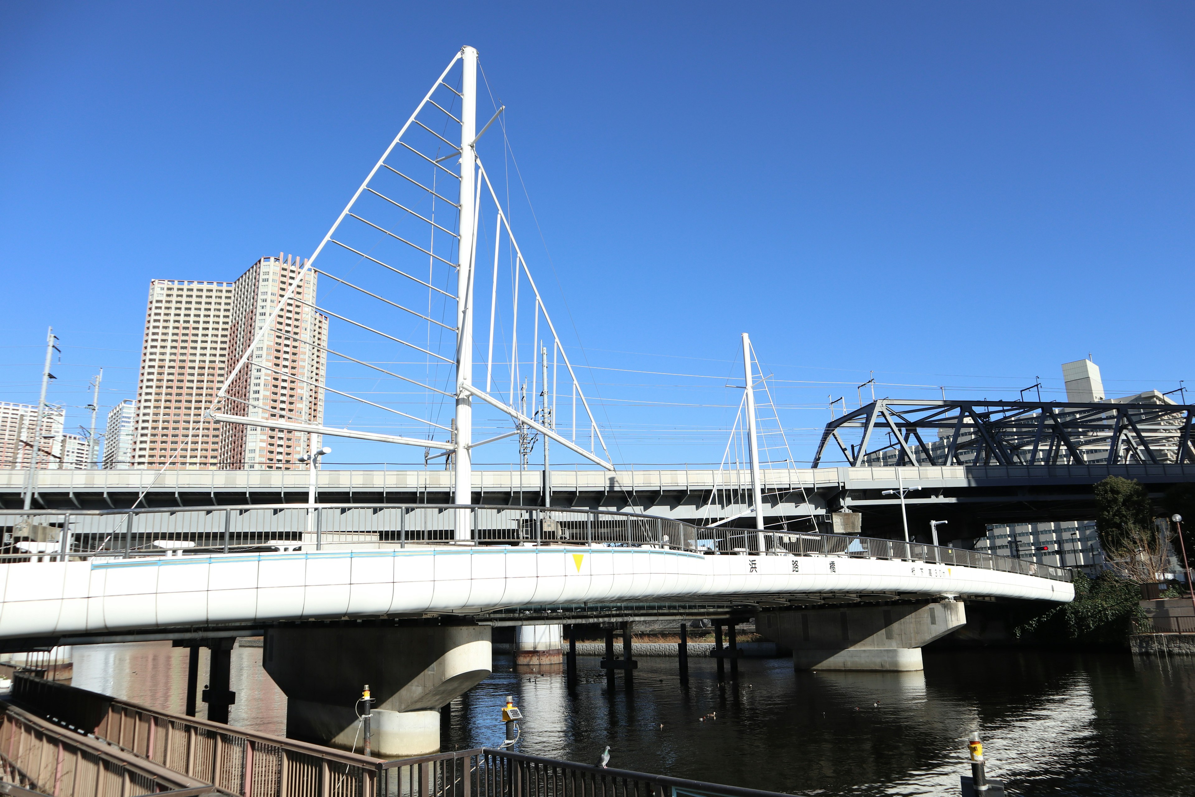 Ponte a travi bianche con grattacieli urbani sotto un cielo blu