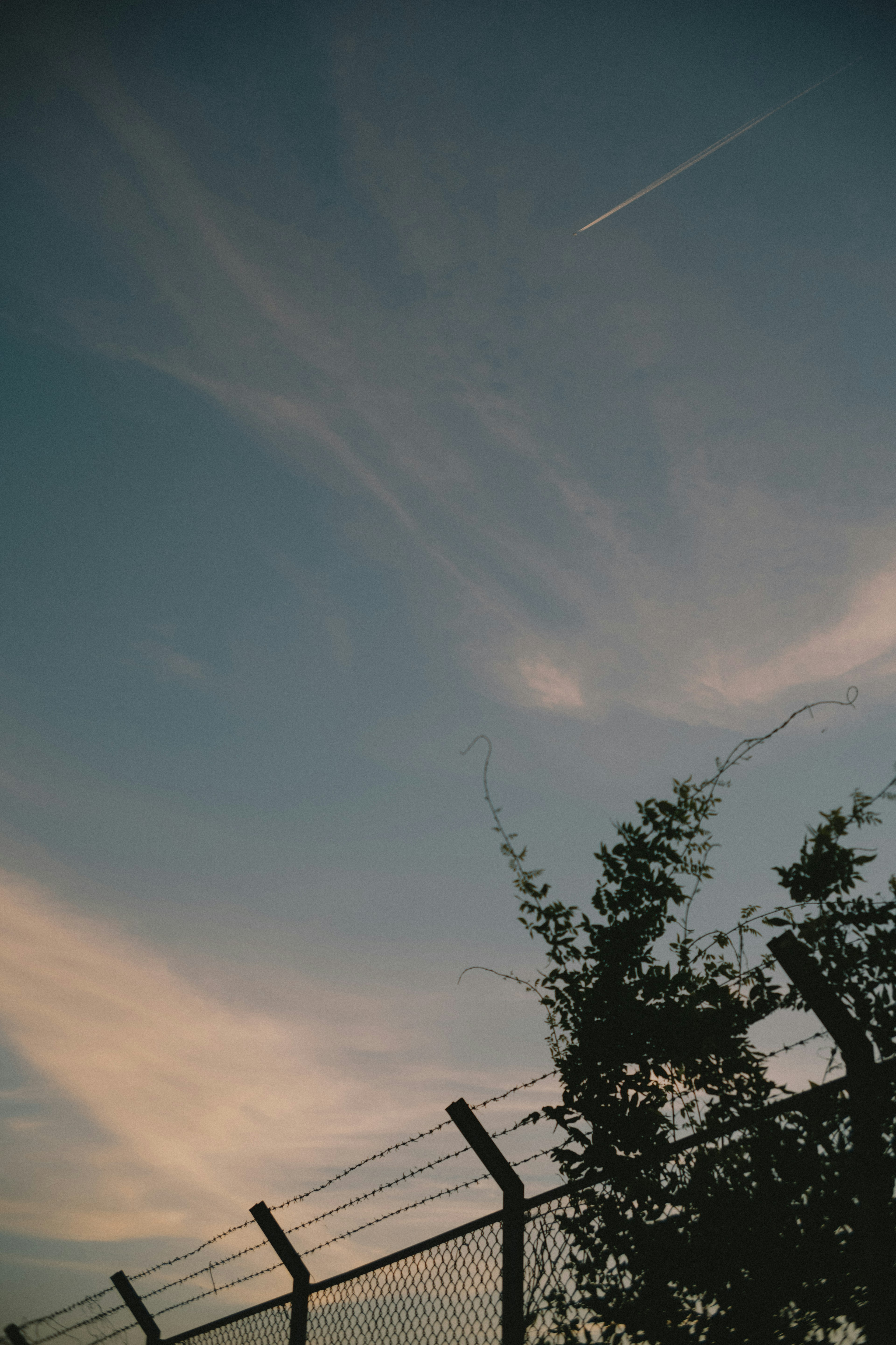 Silhouette of a fence against a sunset sky