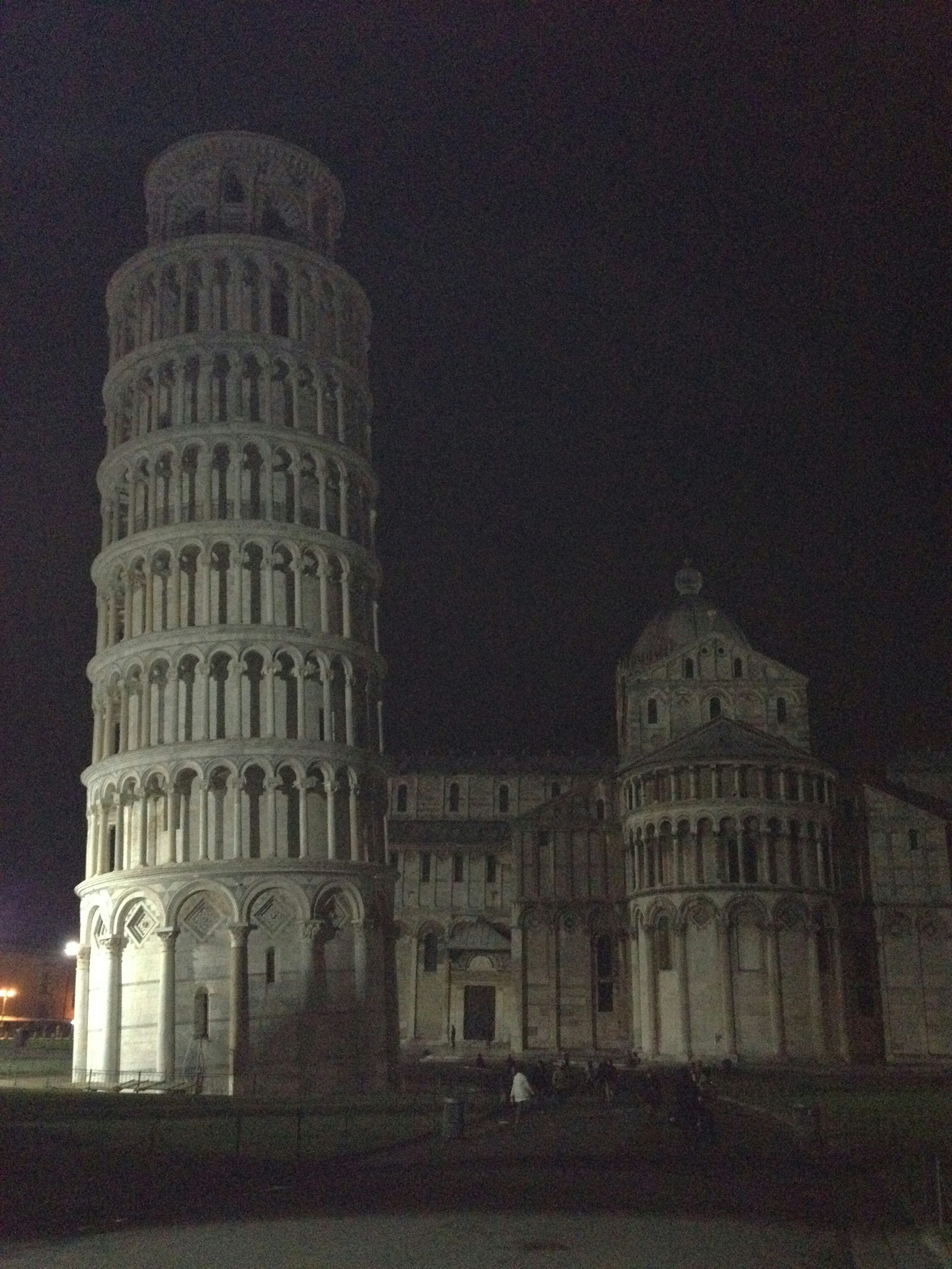 Schiefer Turm von Pisa bei Nacht mit umliegender Architektur