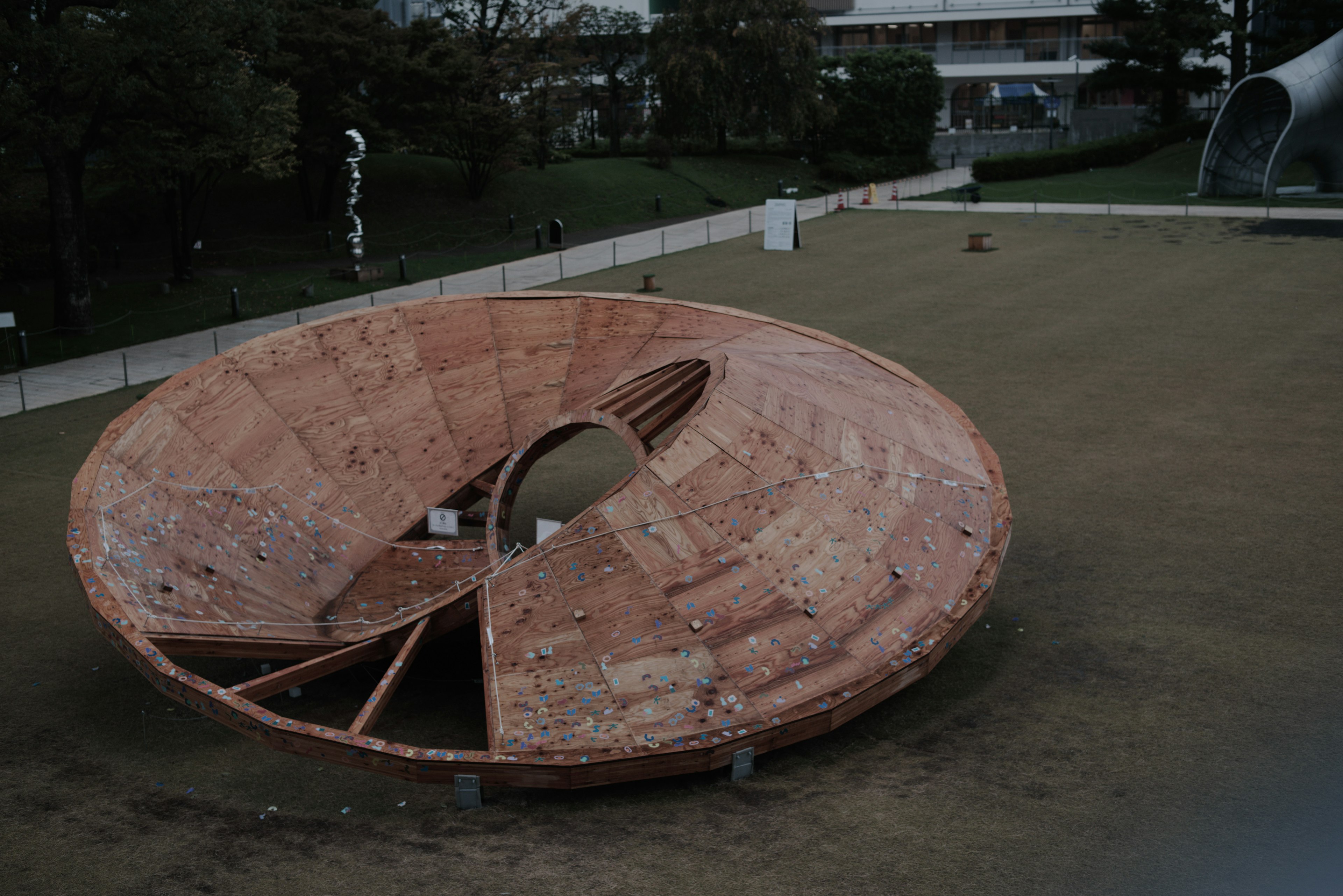 Una escultura circular ubicada en el césped de un parque