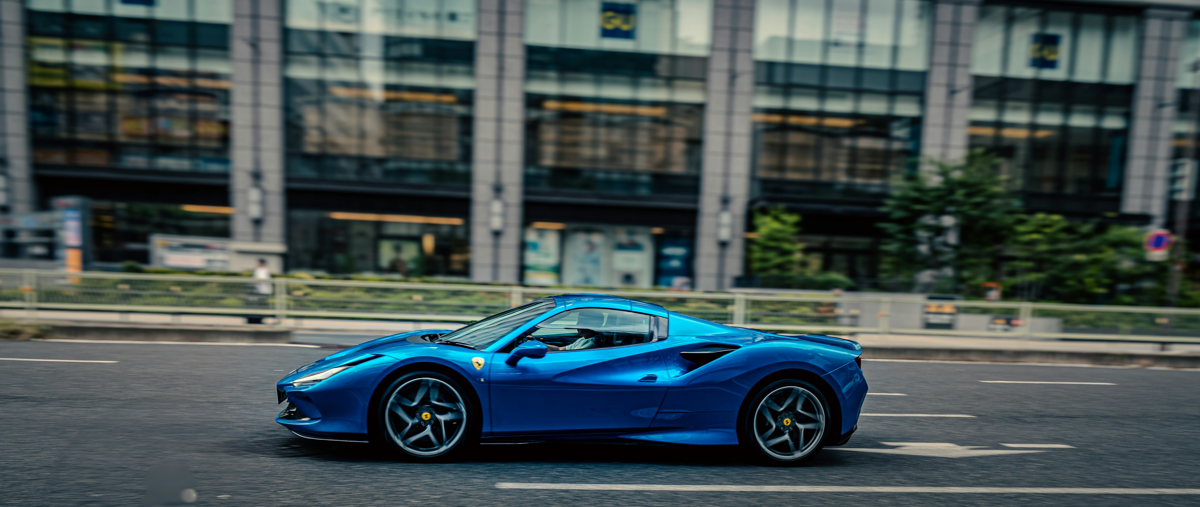 Blue sports car driving on city street