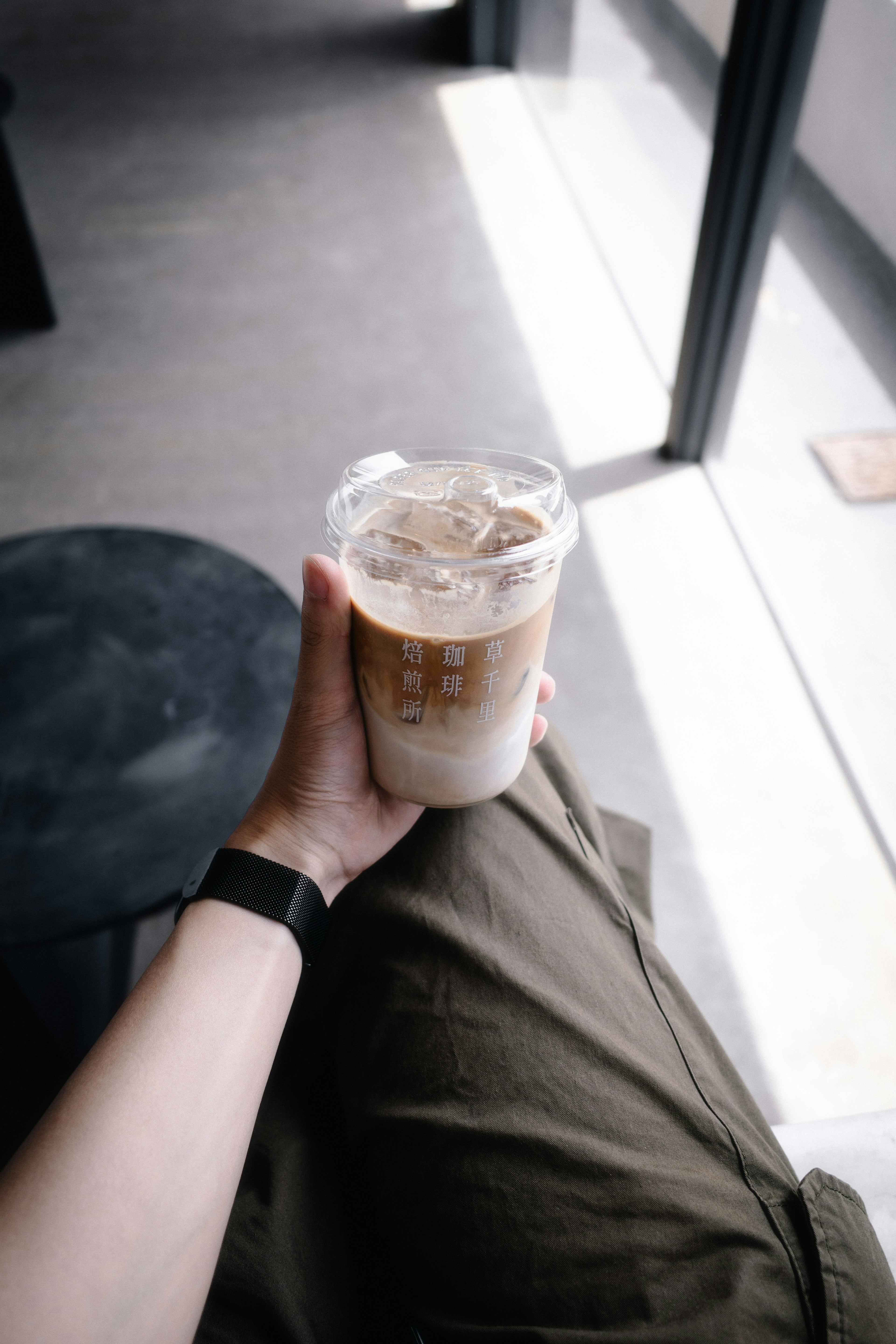 Una mano sosteniendo un café helado en un café