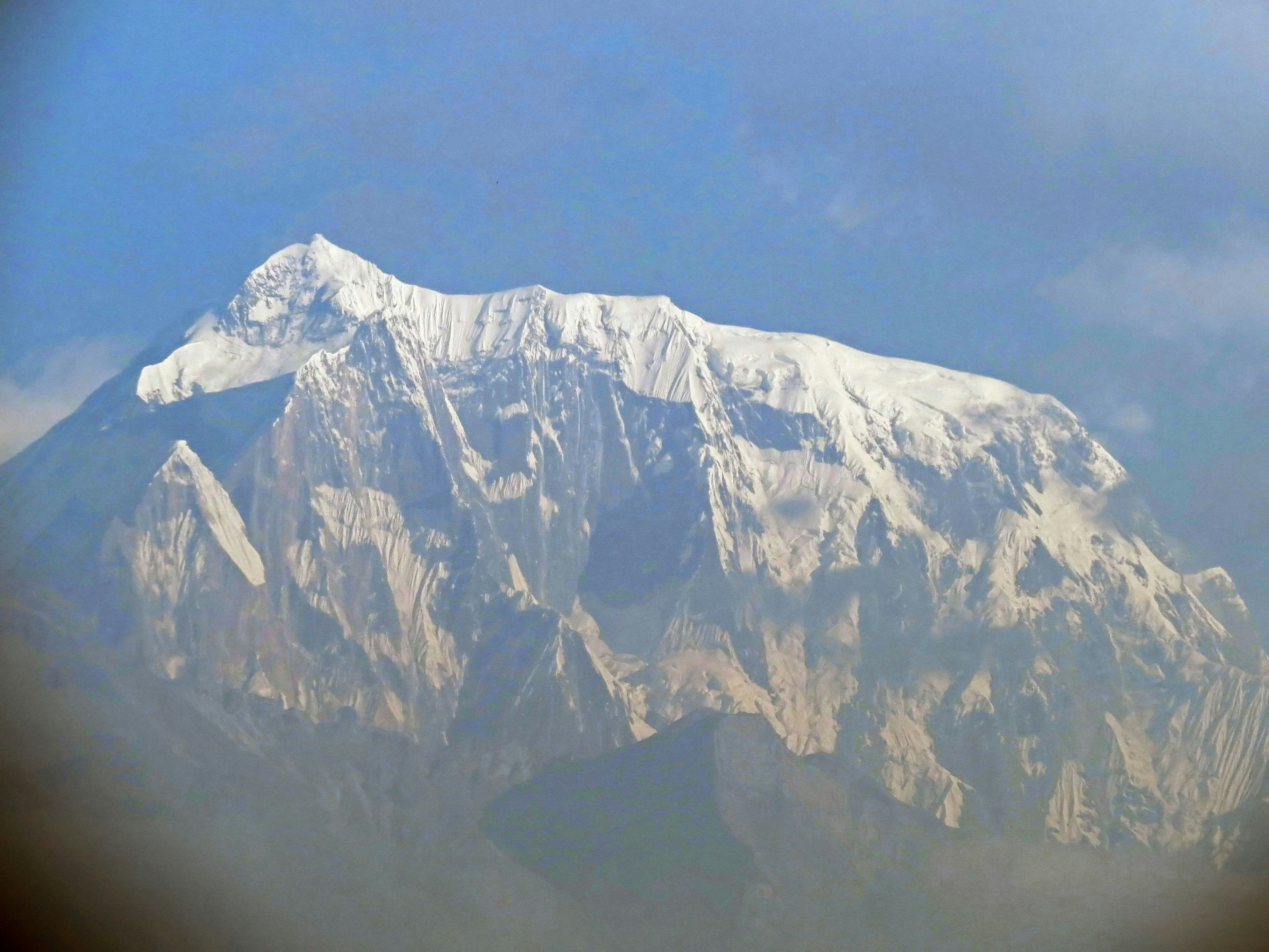 Cima di montagna coperta di neve sotto un cielo blu chiaro