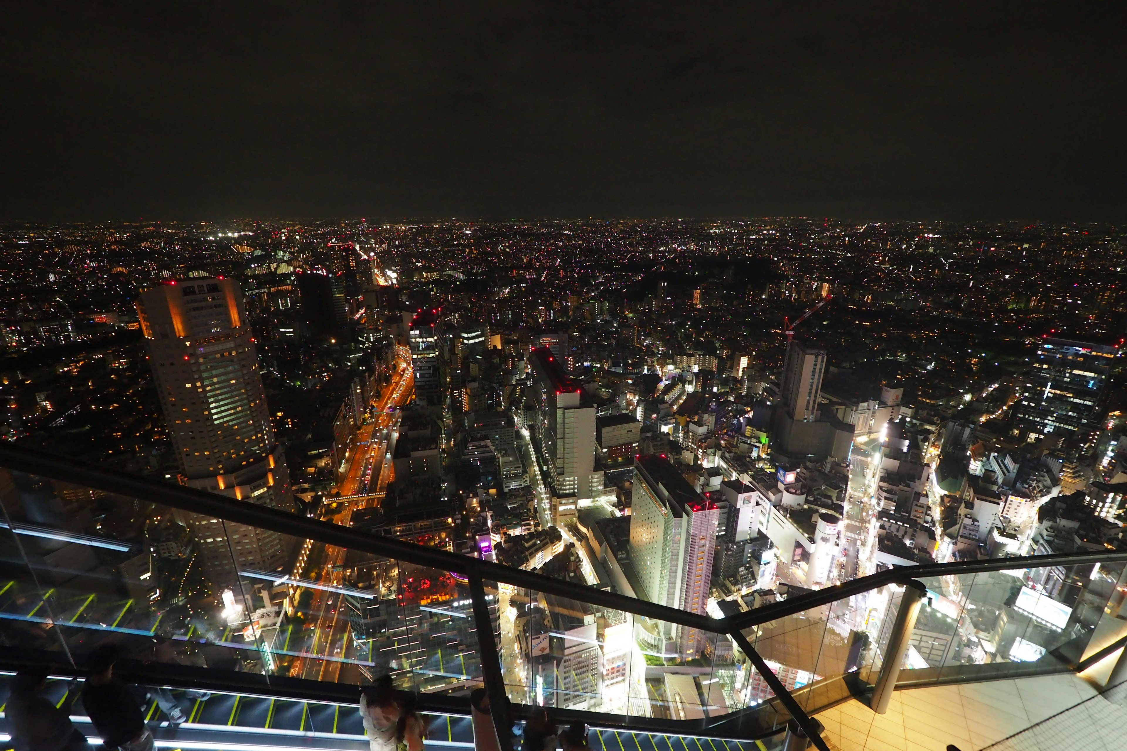 Cảnh nhìn từ đài quan sát nhìn ra đường chân trời đêm Tokyo Ánh đèn thành phố sáng và những tòa nhà chọc trời trải dài trên đường chân trời