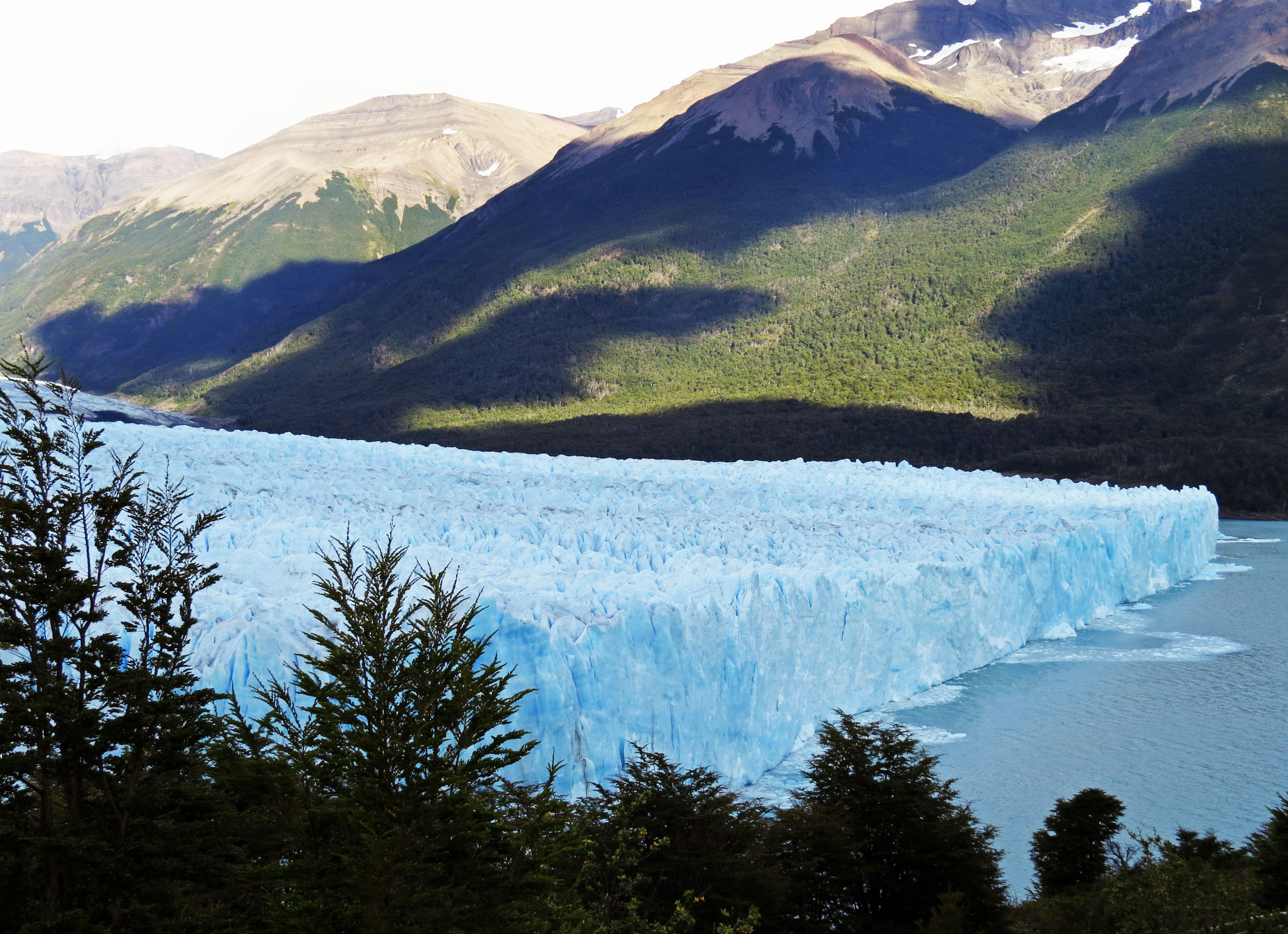 Impresionante vista de un glaciar azul fluyendo hacia un lago