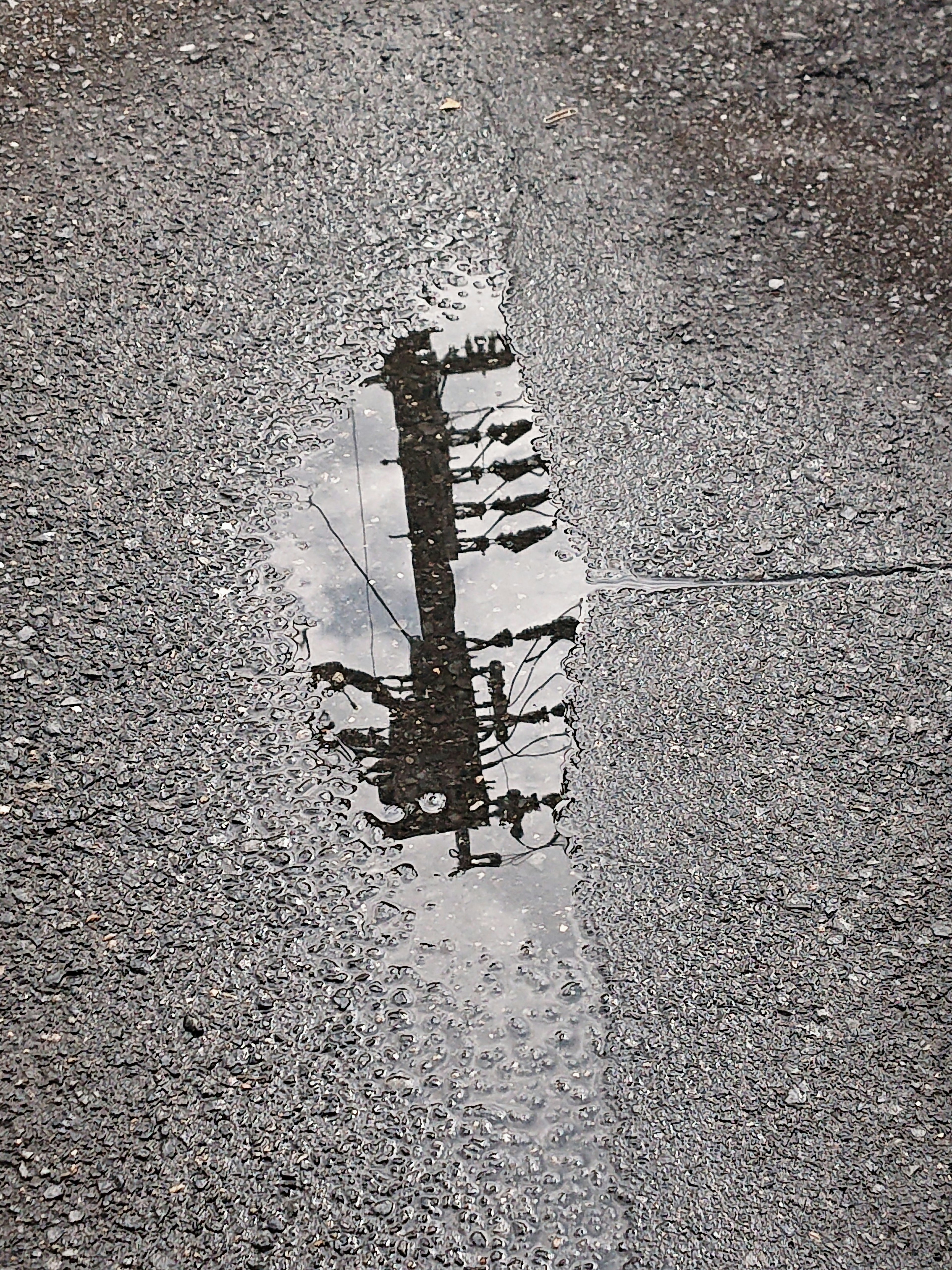 Reflection of a building silhouette in a puddle on asphalt