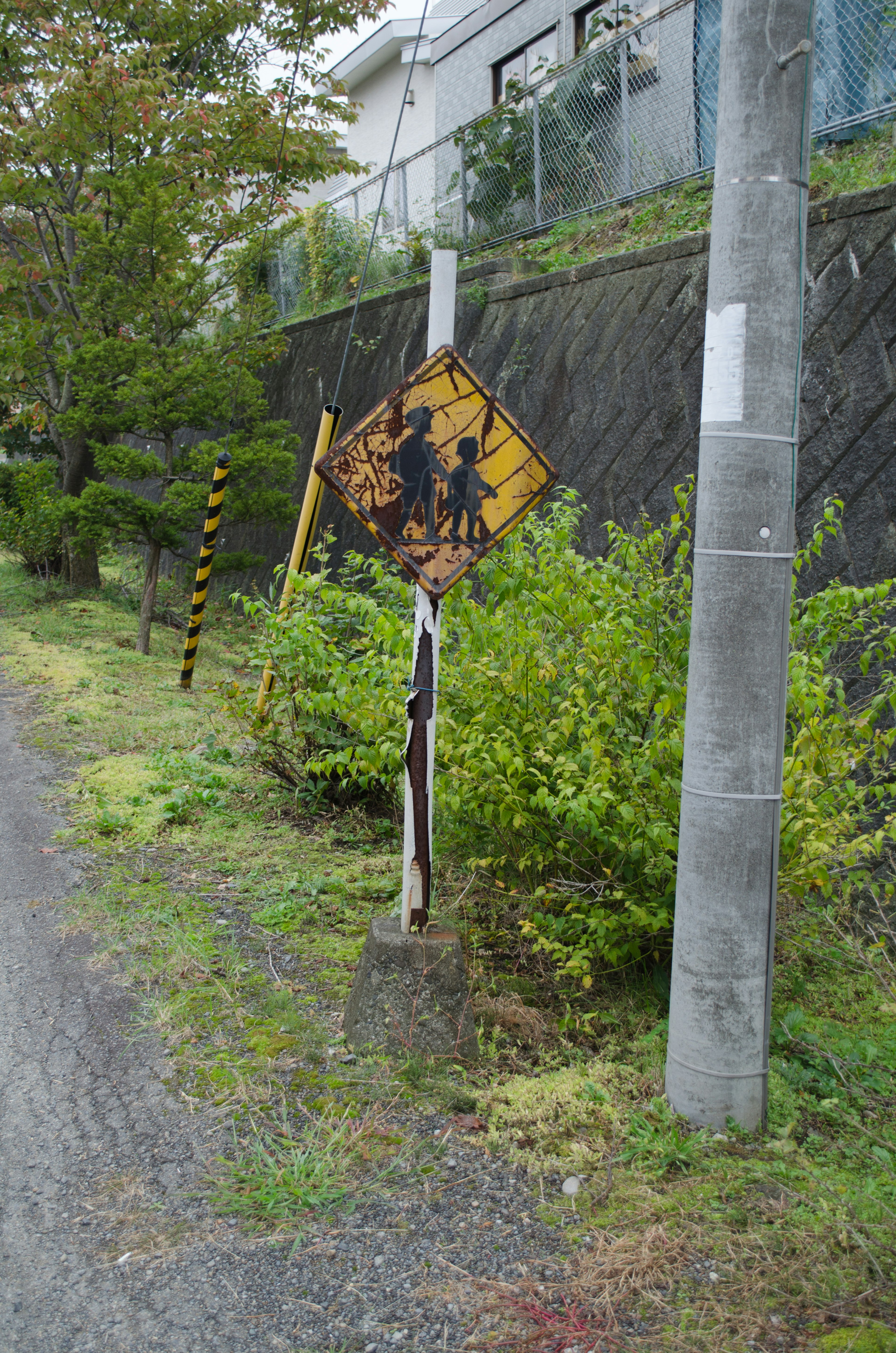 Old warning sign along the road featuring illustrations of children