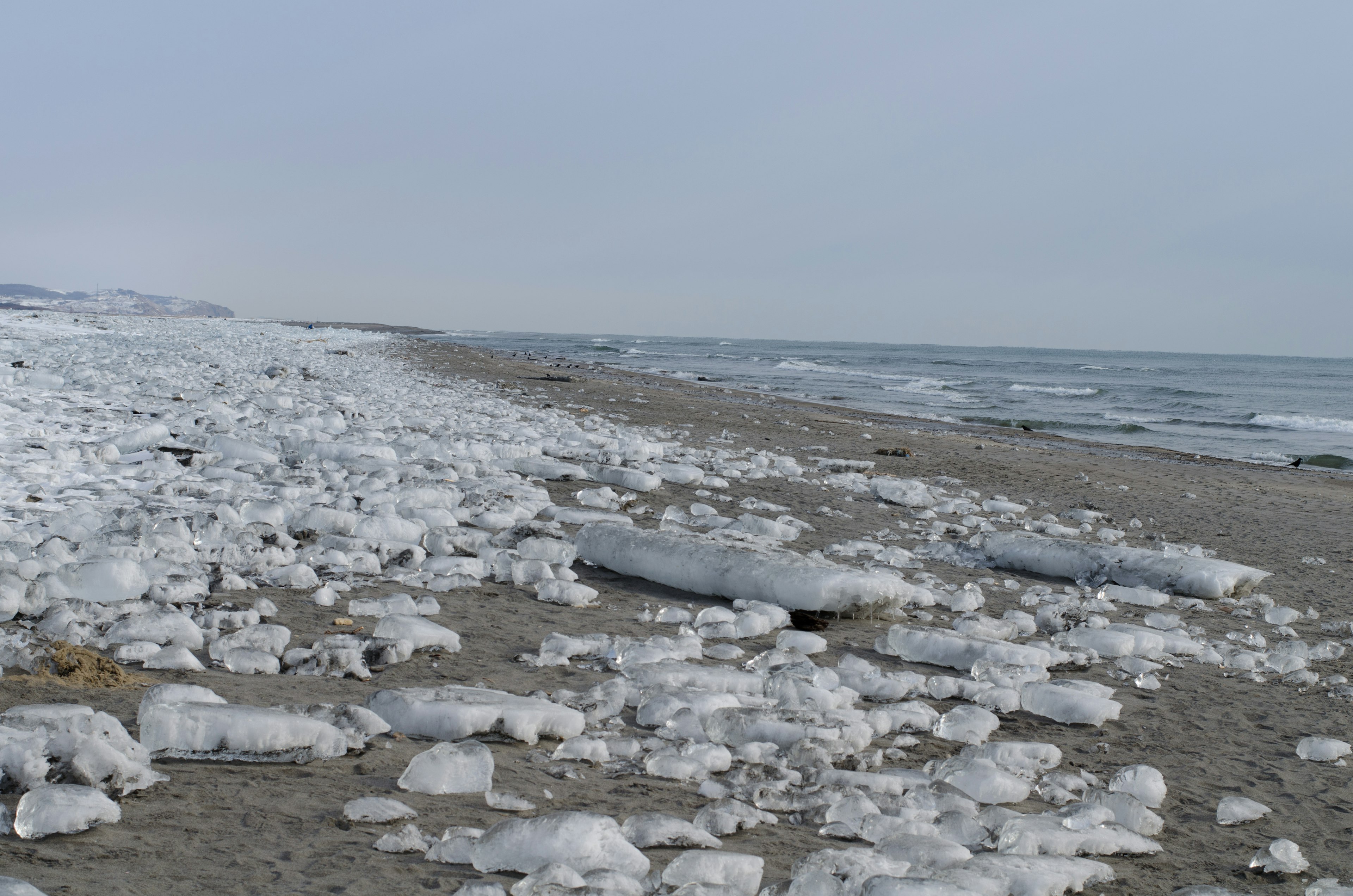 Strandszene mit verstreuten Eisklumpen