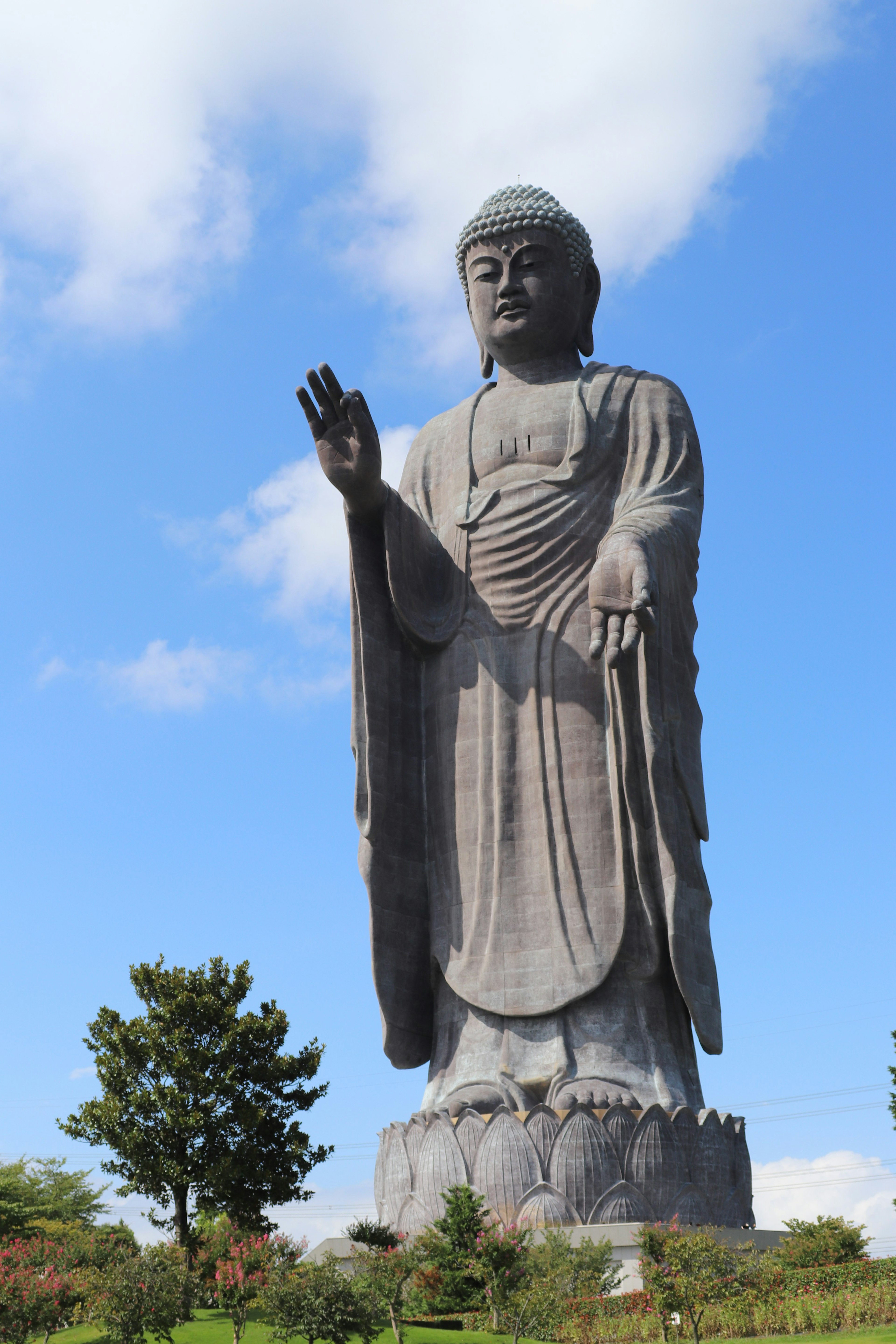 Grande statua di Buddha che si erge sotto un cielo azzurro