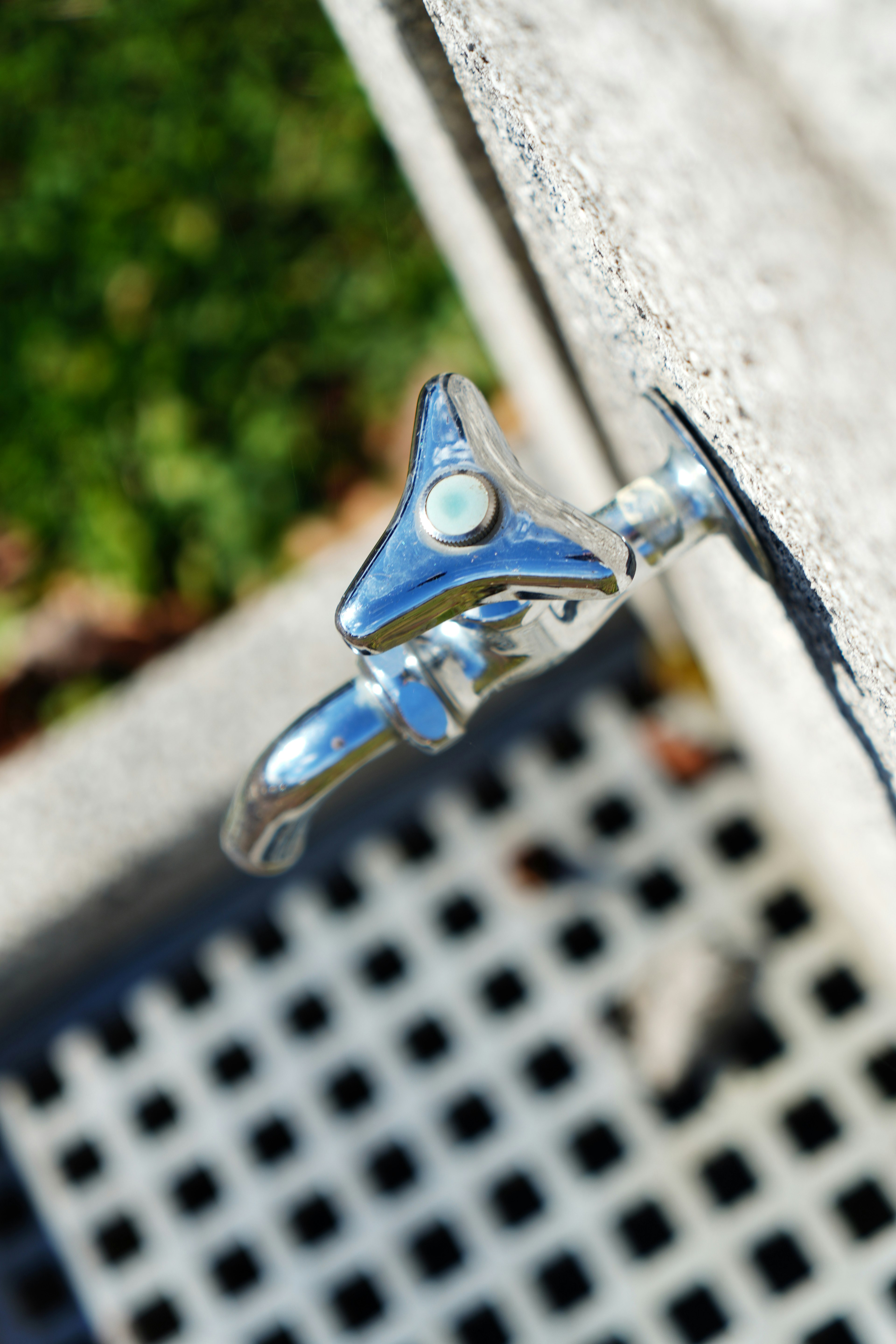 Image of a metal water faucet mounted on a concrete surface