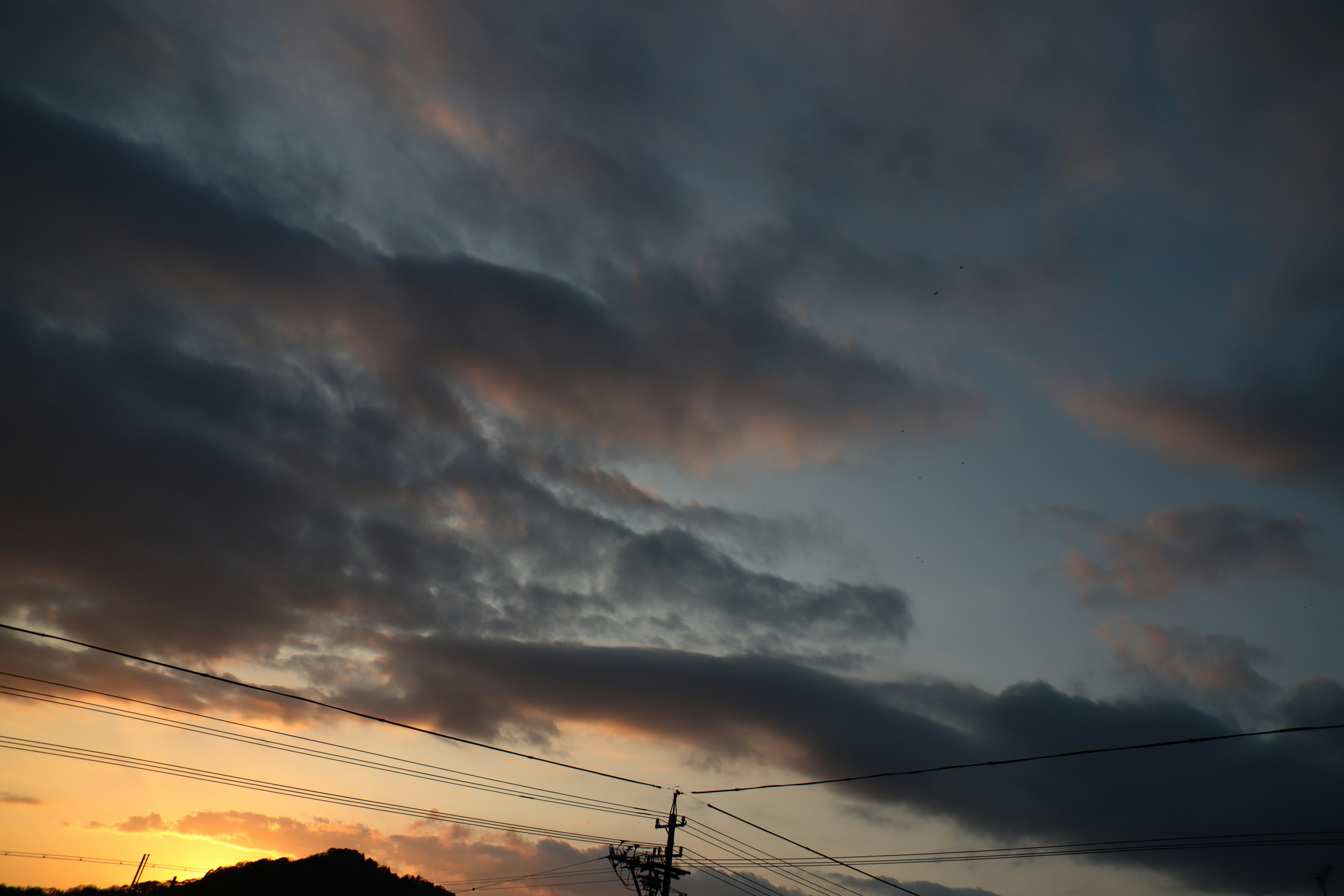 Ciel au coucher de soleil avec des nuages et silhouette d'une montagne