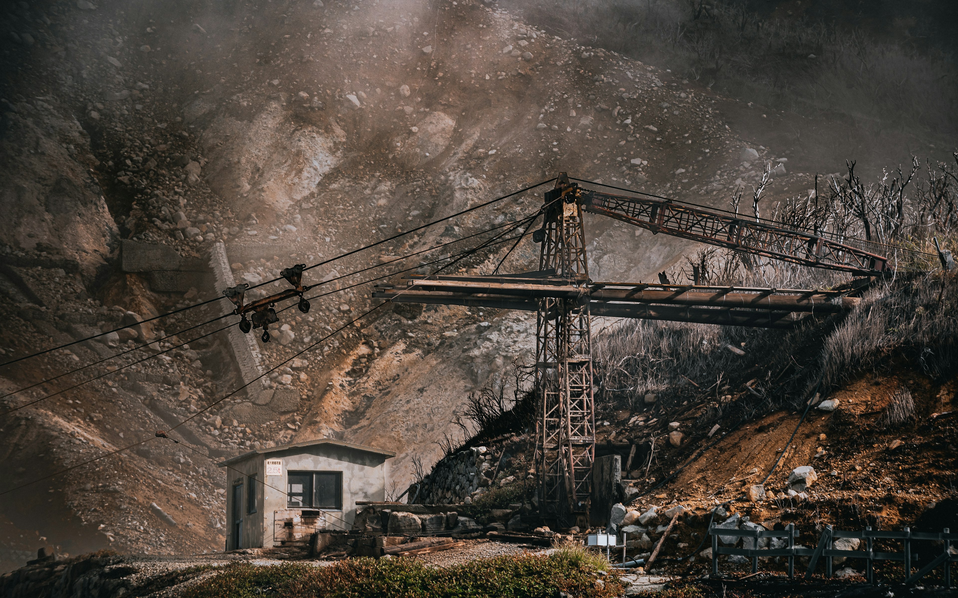 Image d'une vieille grue et d'un petit bâtiment sur fond de montagne