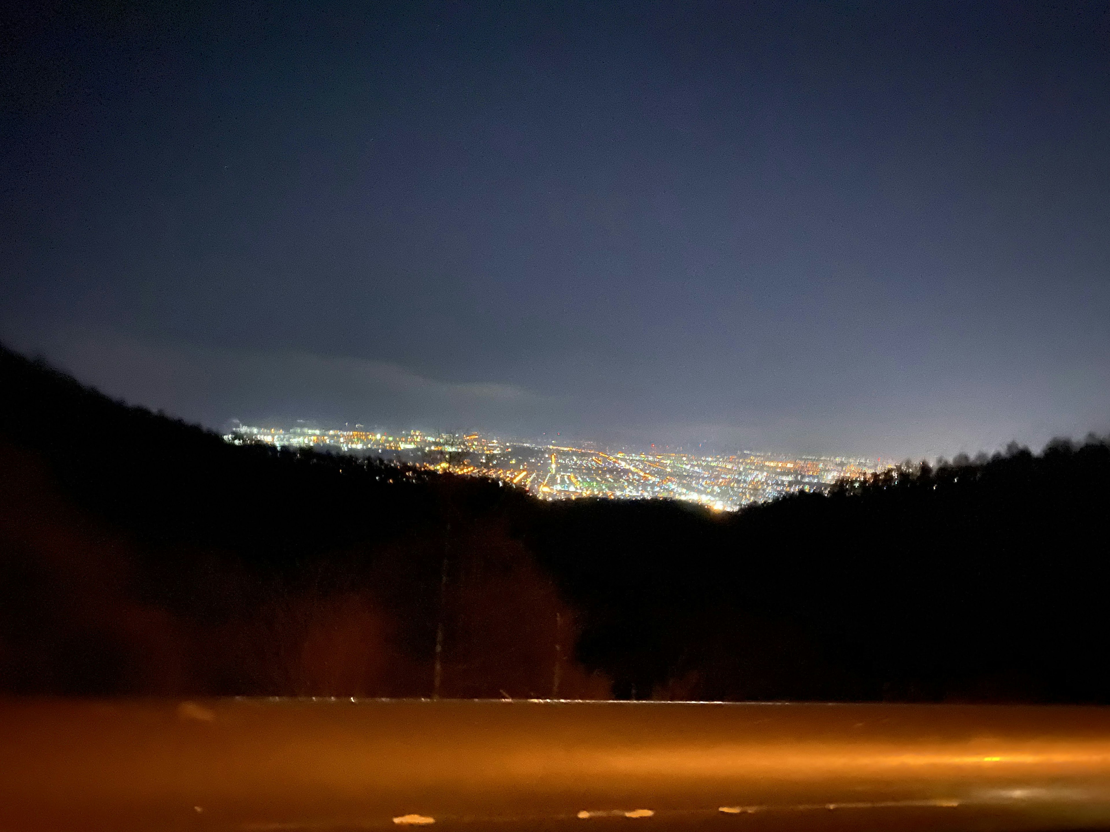 Vista nocturna de un horizonte urbano con luces distantes