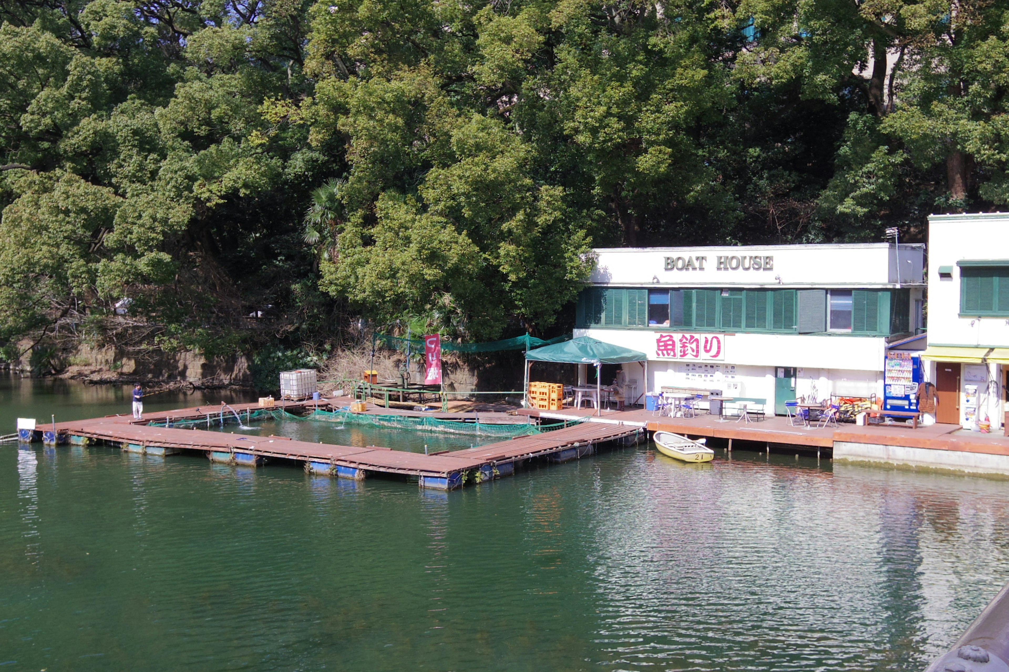 Wasserrandrestaurant mit Holzterrasse, umgeben von Grün