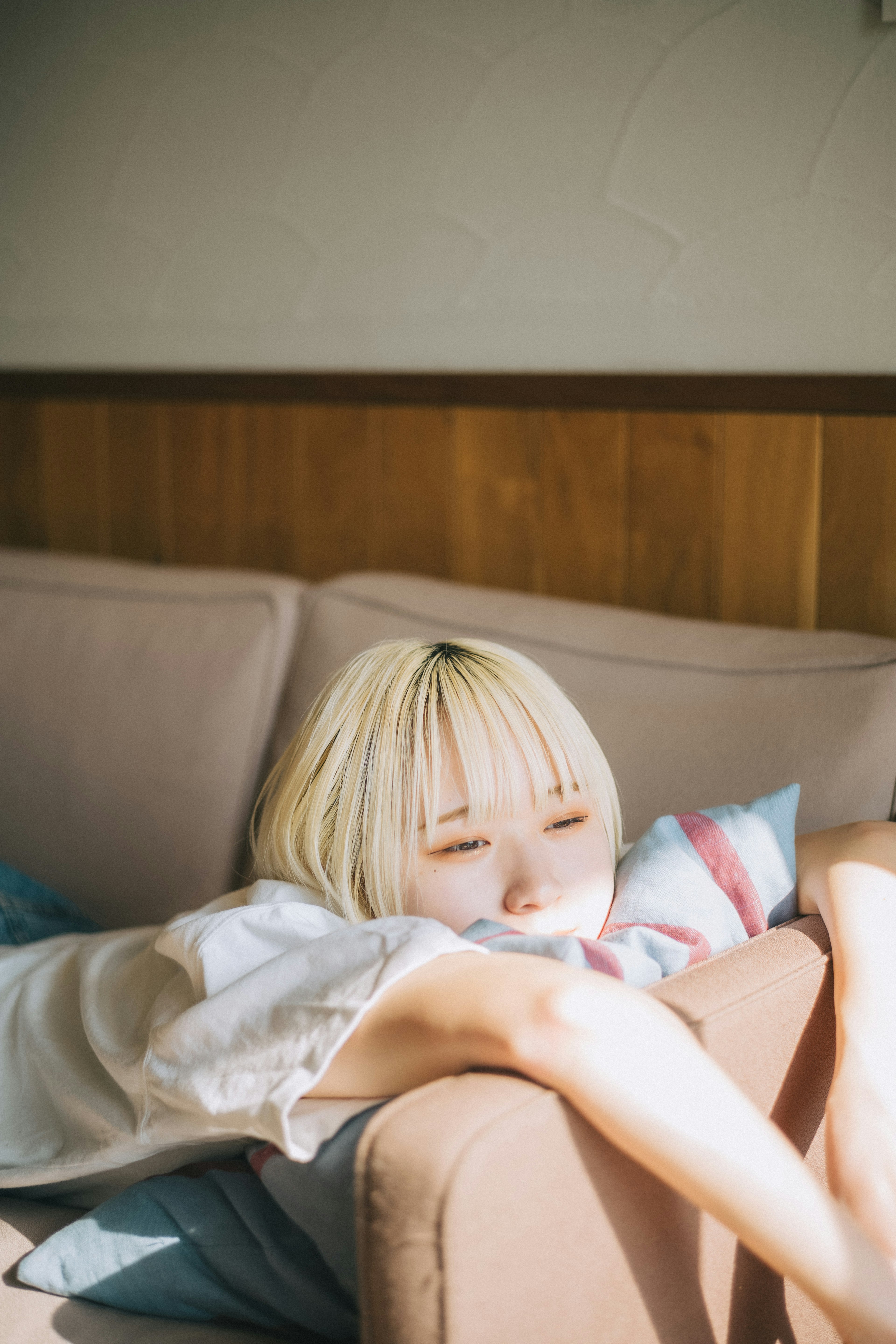 Femme blonde détendue allongée sur un canapé