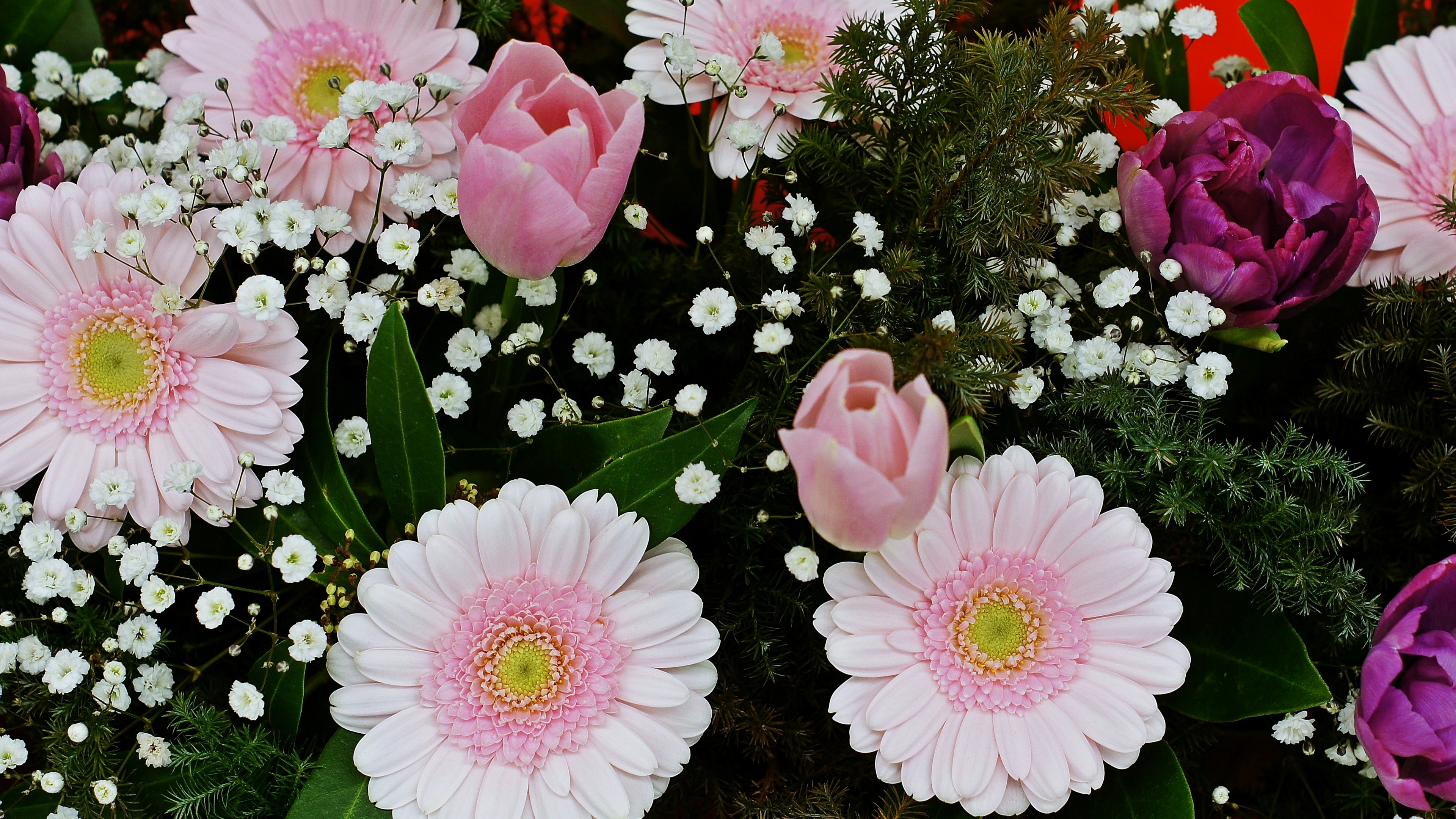 Ein schöner Blumenstrauß mit rosa Blumen und Akzenten in Rot und Lila