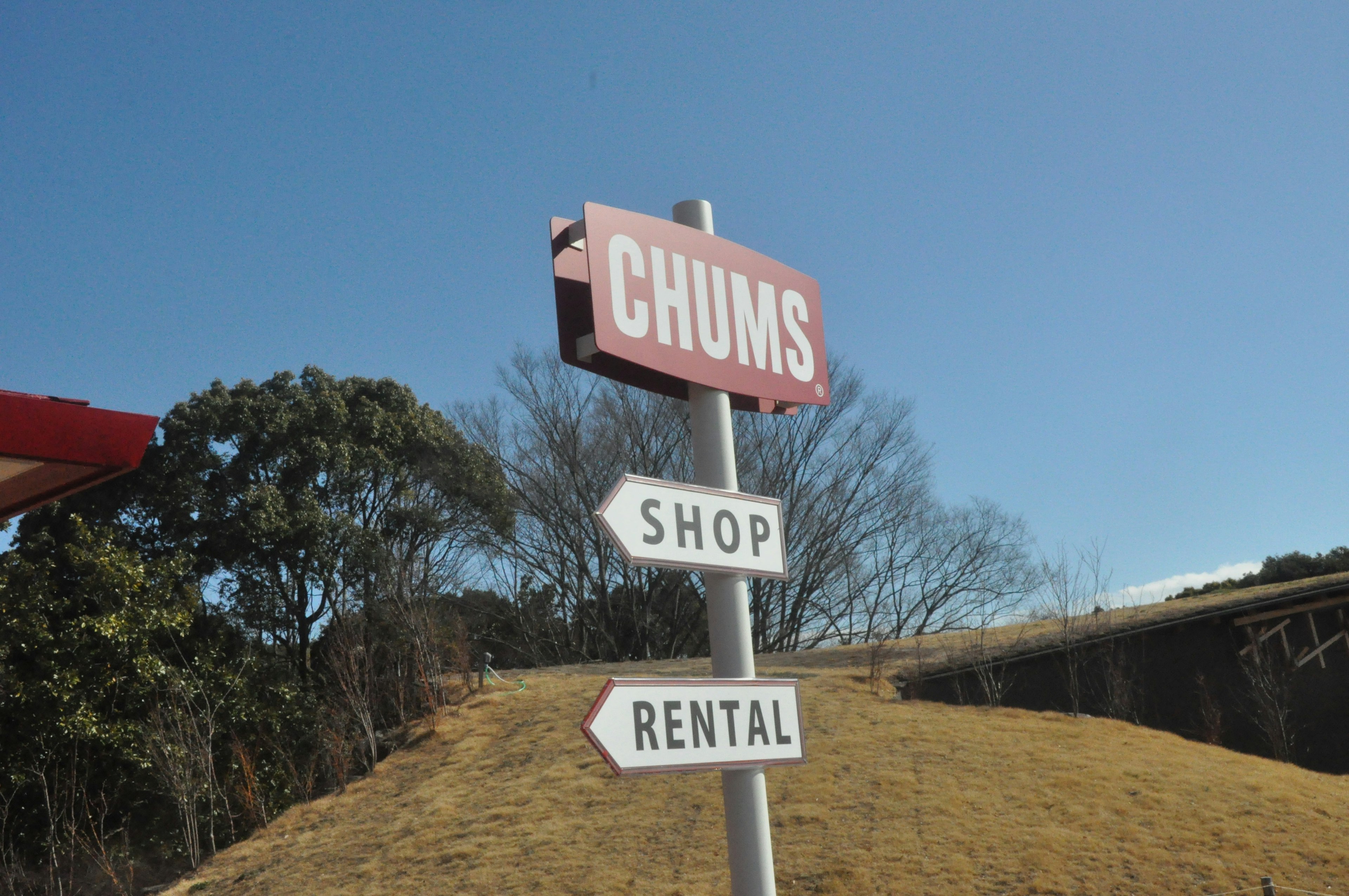 Sign for CHUMS indicating directions to Shop and Rental