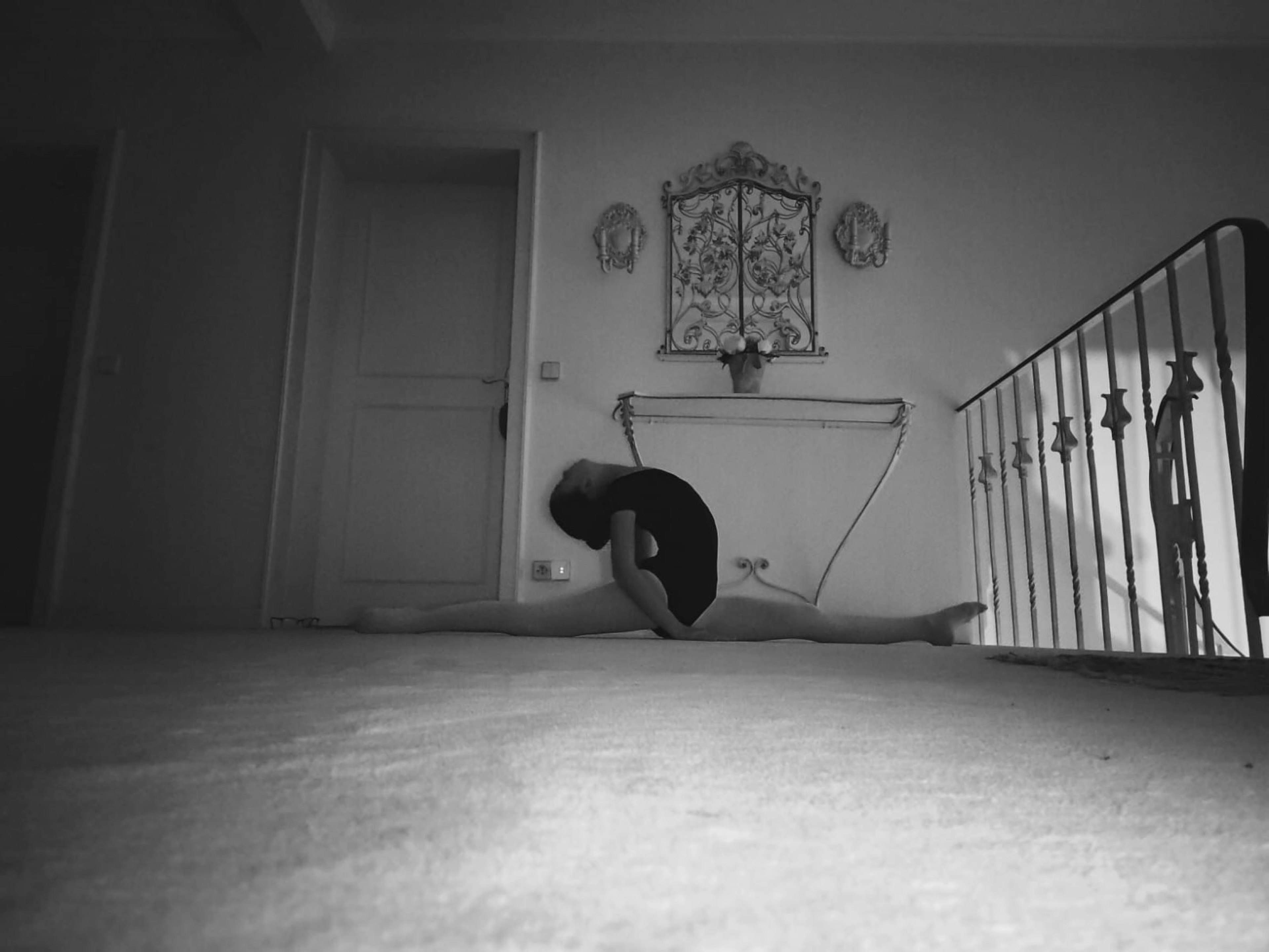 Person stretching in a black and white room with wall art