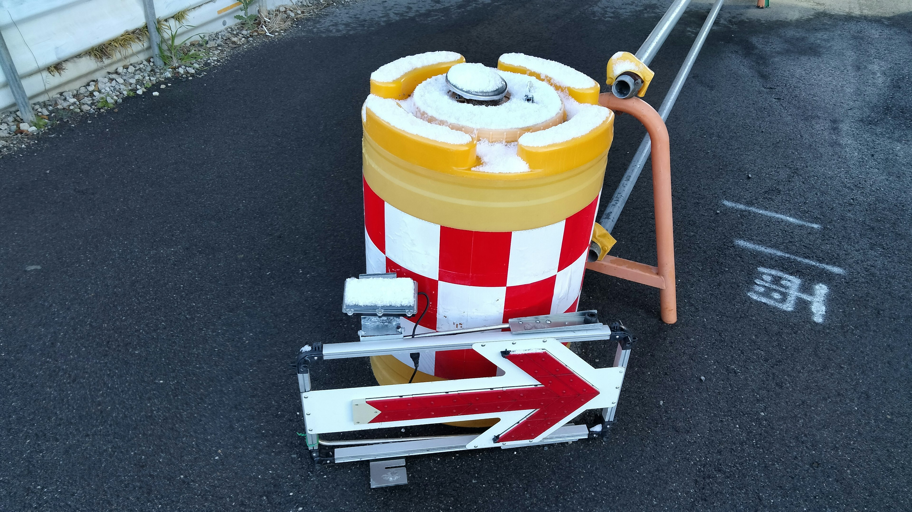 Machine de travaux routiers avec un motif à carreaux jaunes et rouges et flèche directionnelle