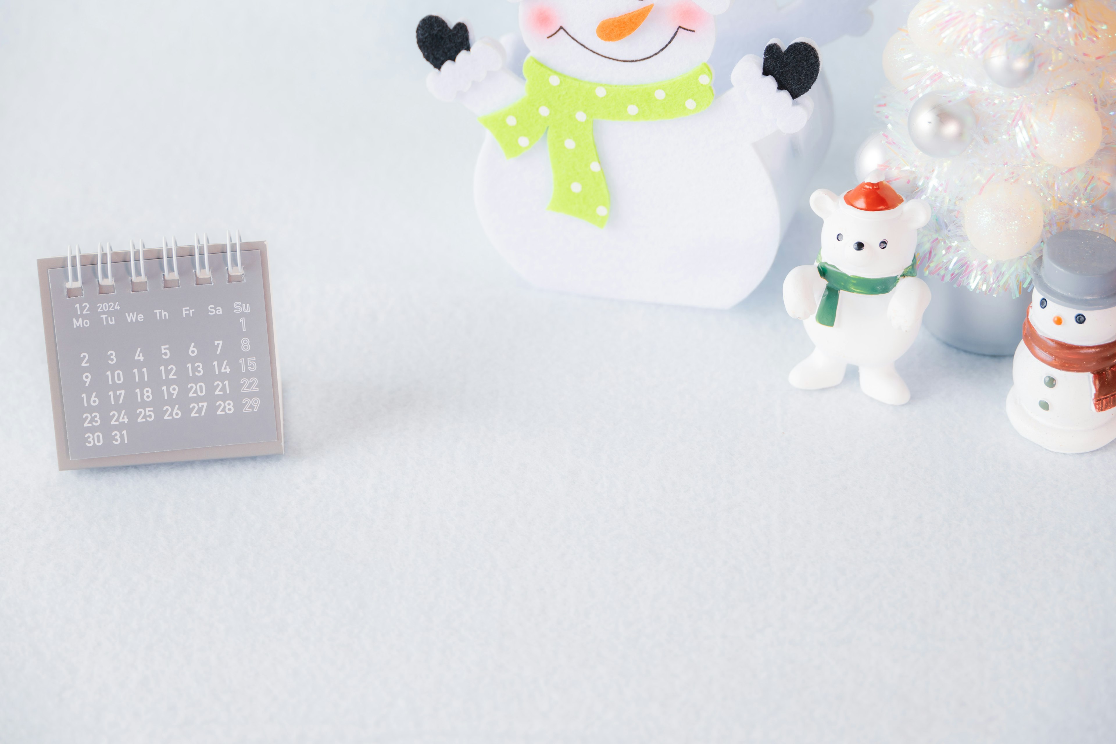 Escena invernal con un muñeco de nieve y una decoración de calendario