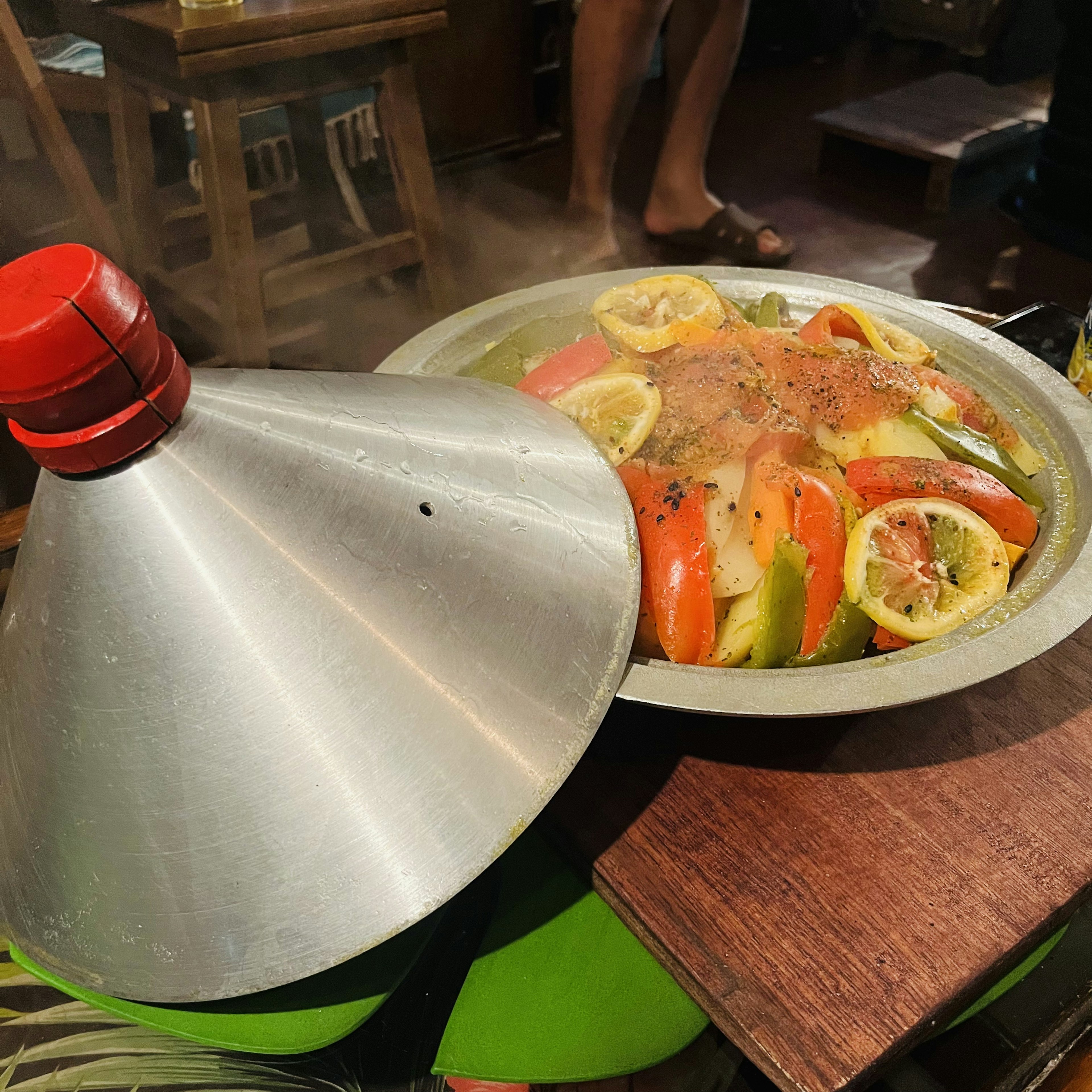 Steaming dish of fresh vegetables and lemon in a tagine pot