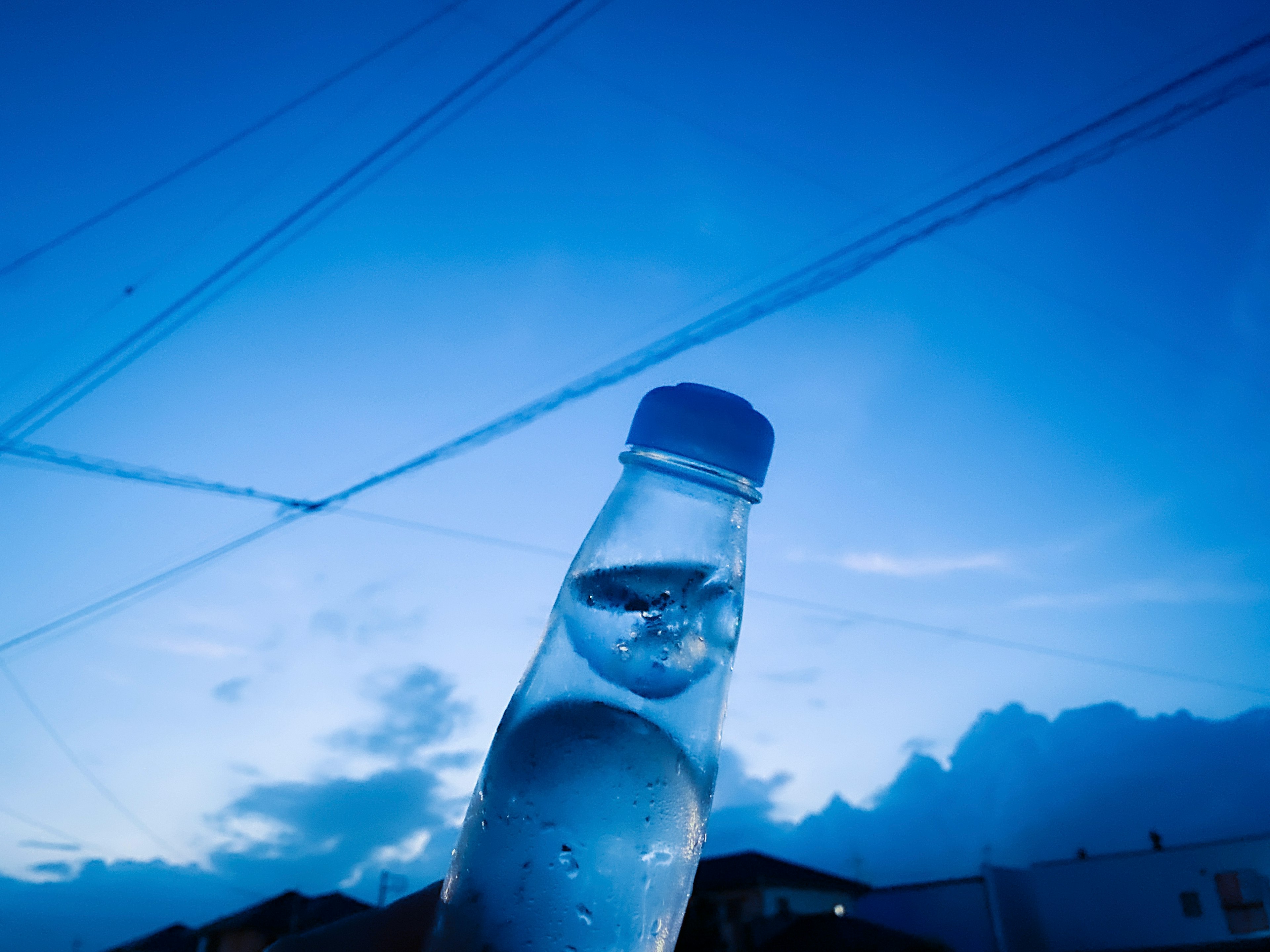 Botol air transparan di latar belakang langit biru