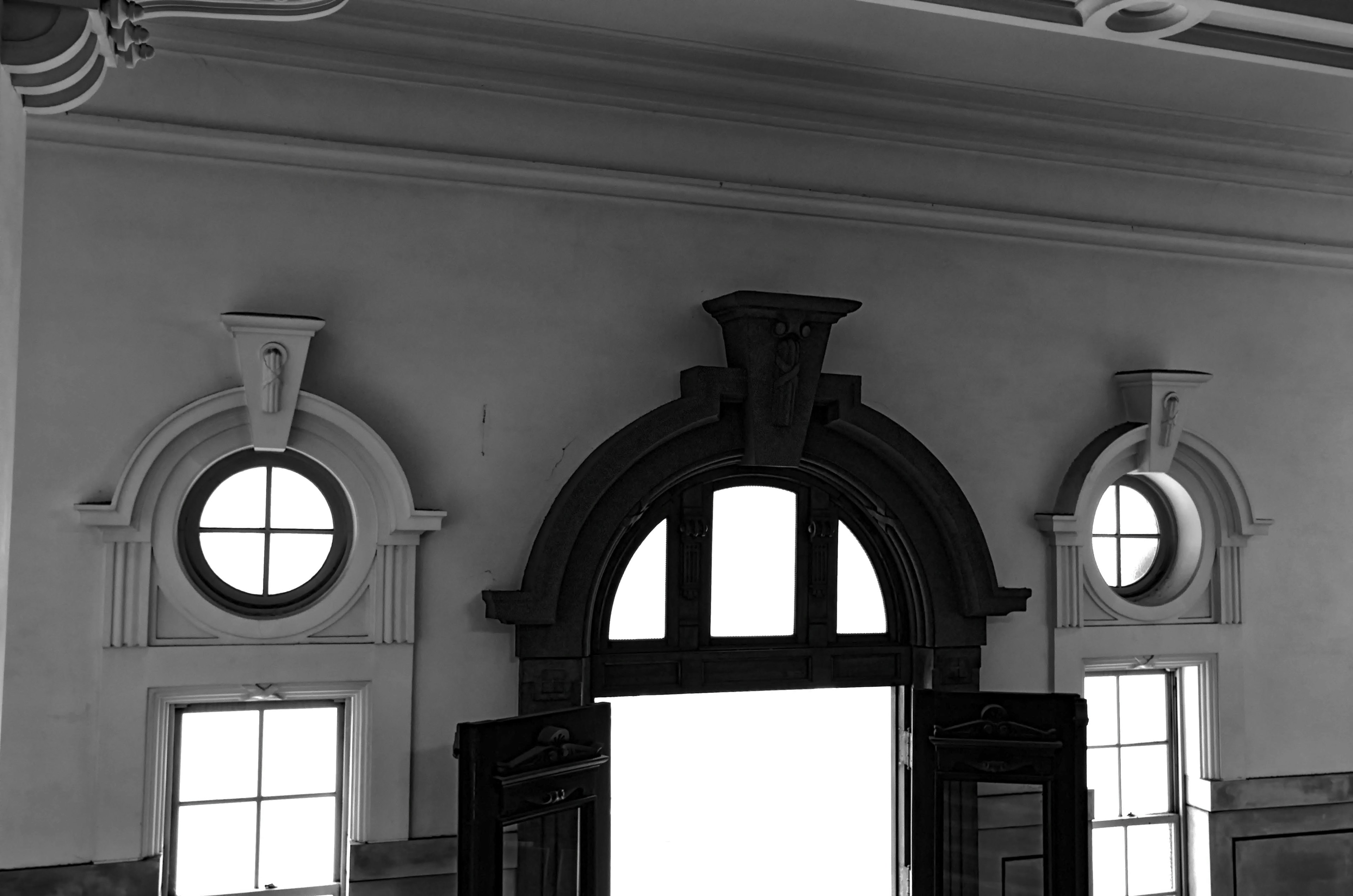 Interior con un marco de puerta decorativo en blanco y negro y ventanas circulares