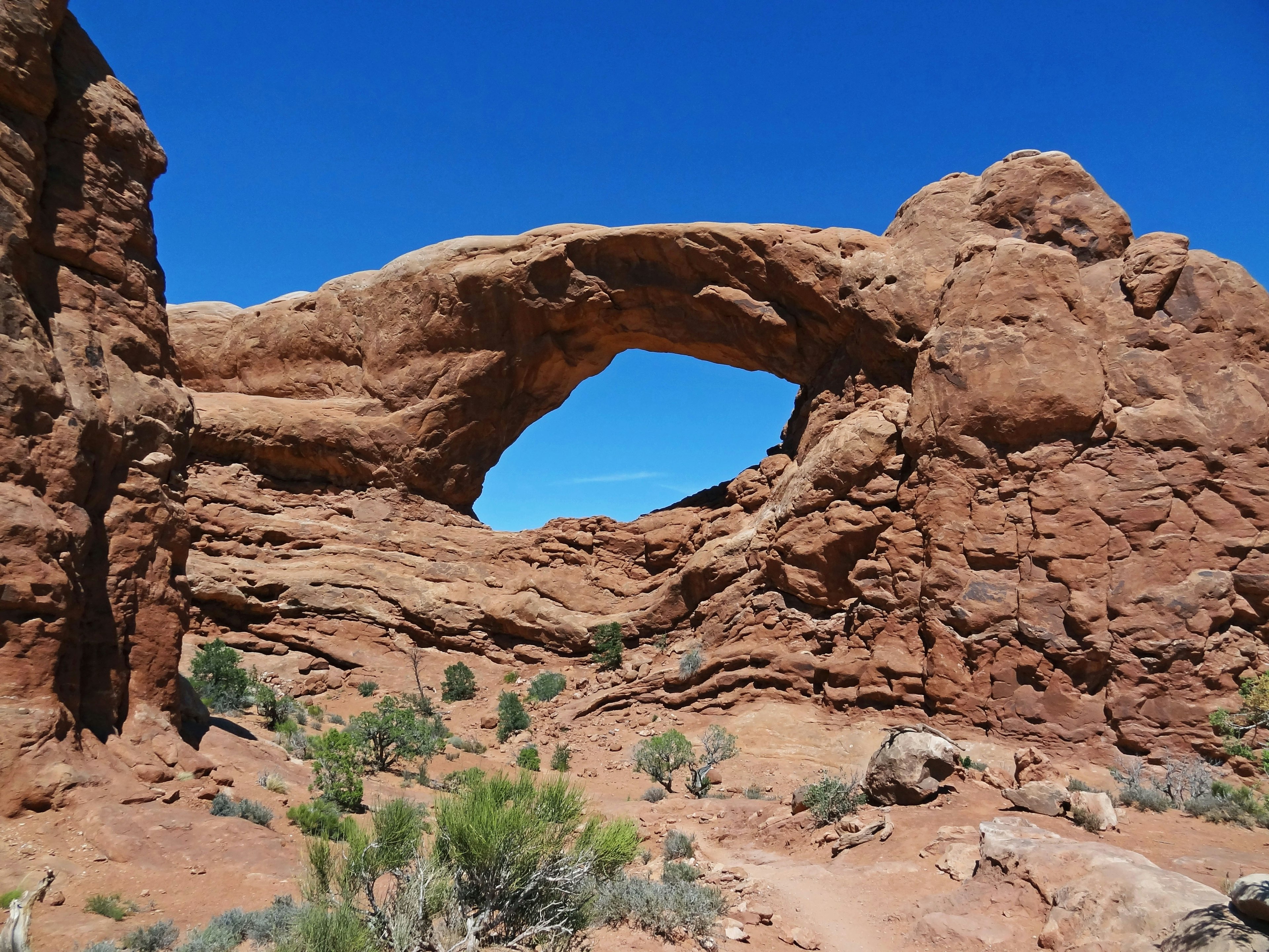 Arco di roccia rossa sotto un cielo blu chiaro