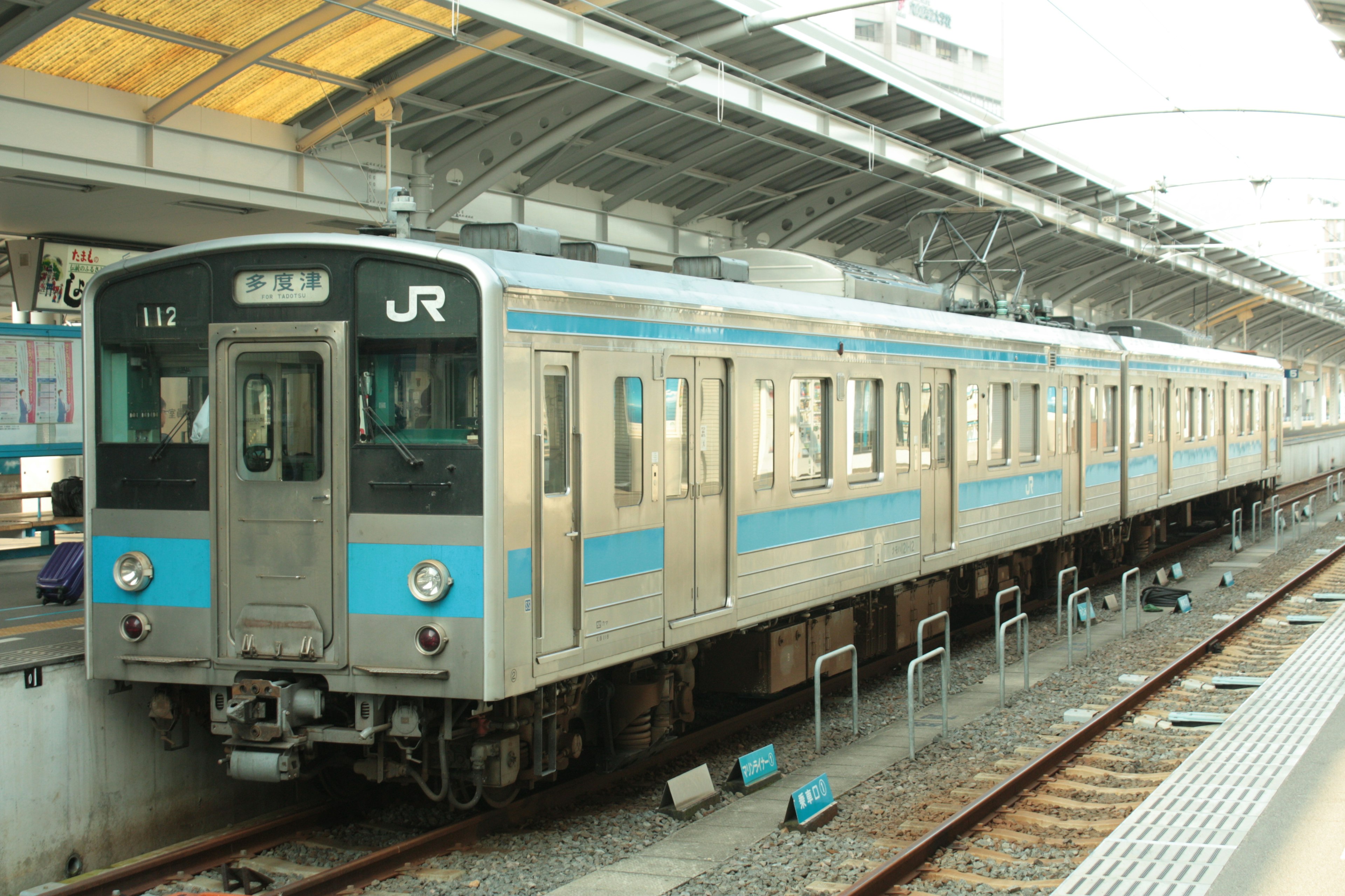 JR-Zug mit blauer Linie am Bahnhof geparkt