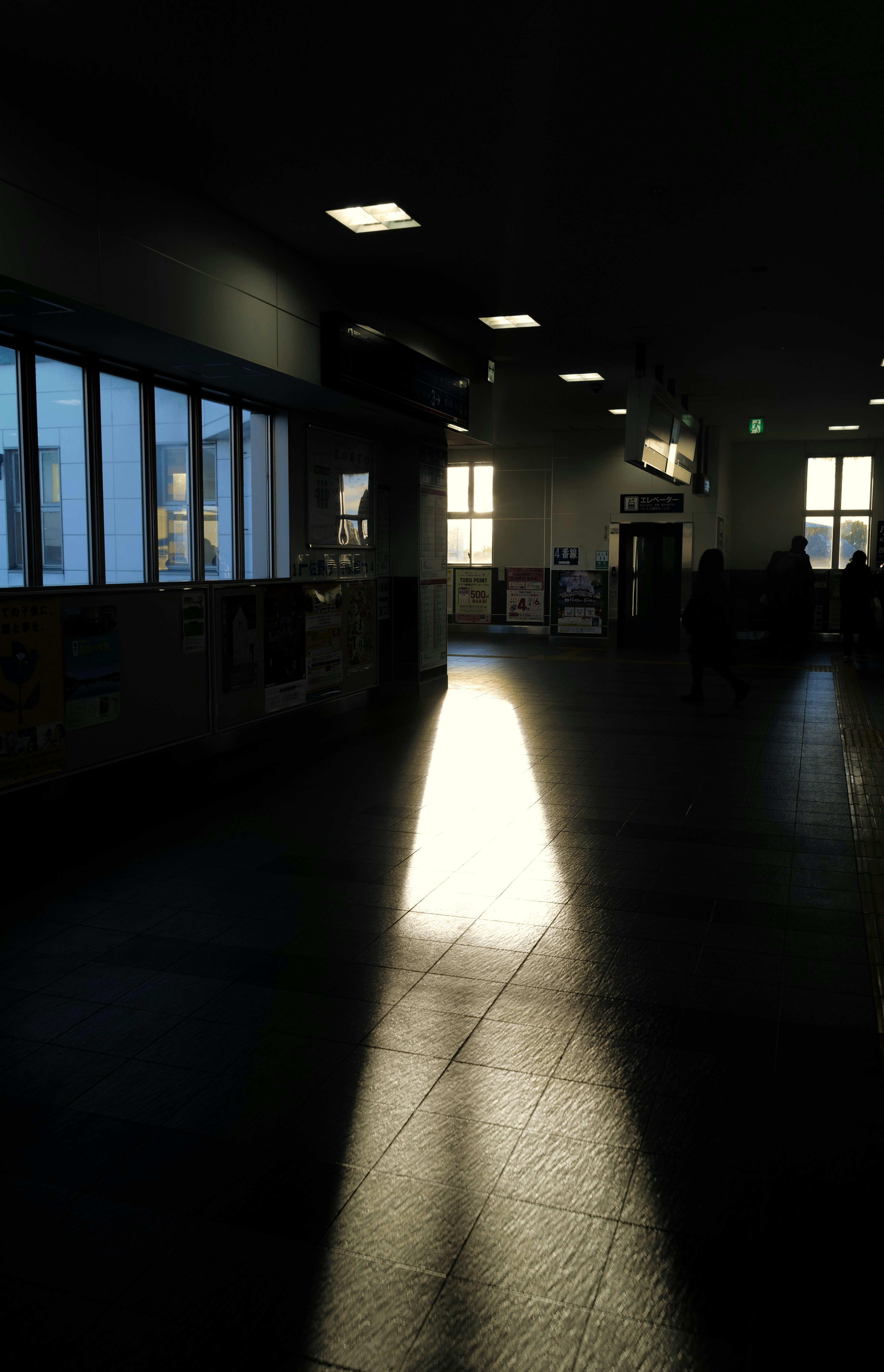 Rayo de luz iluminando un interior tenuemente iluminado con siluetas de ventanas