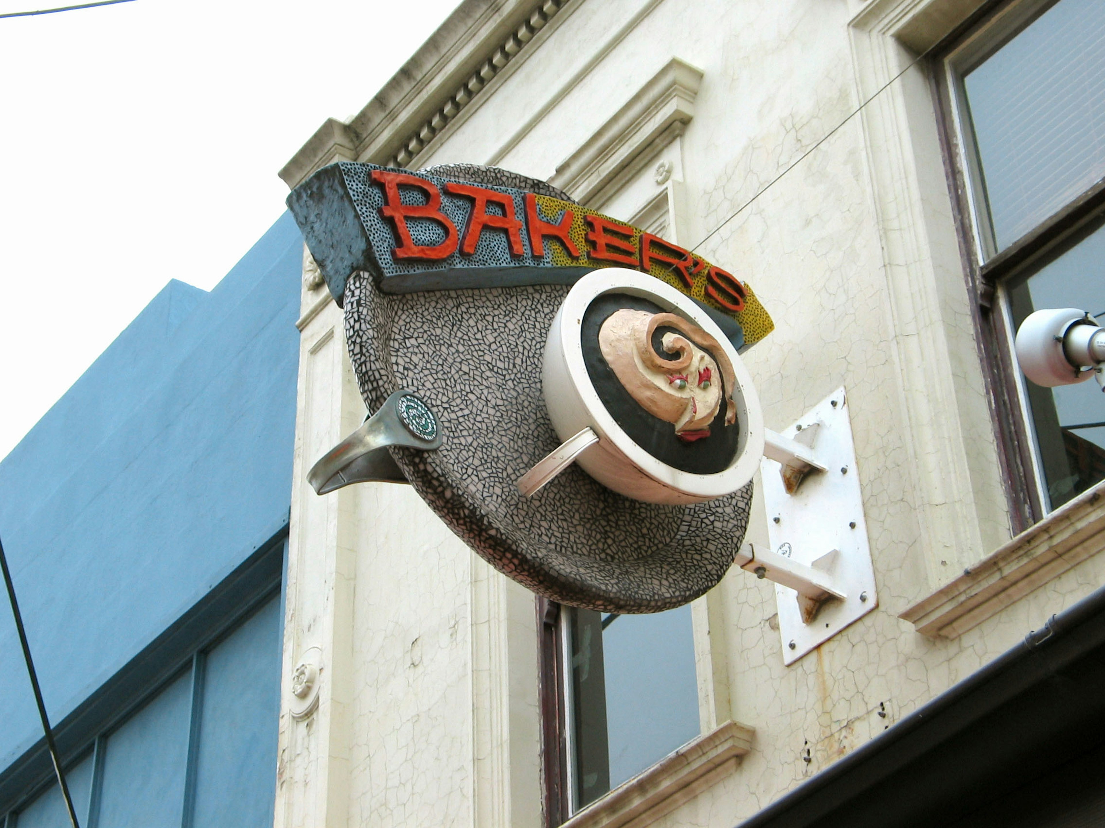 Unique barber shop sign featuring silver and orange colors with a circular design