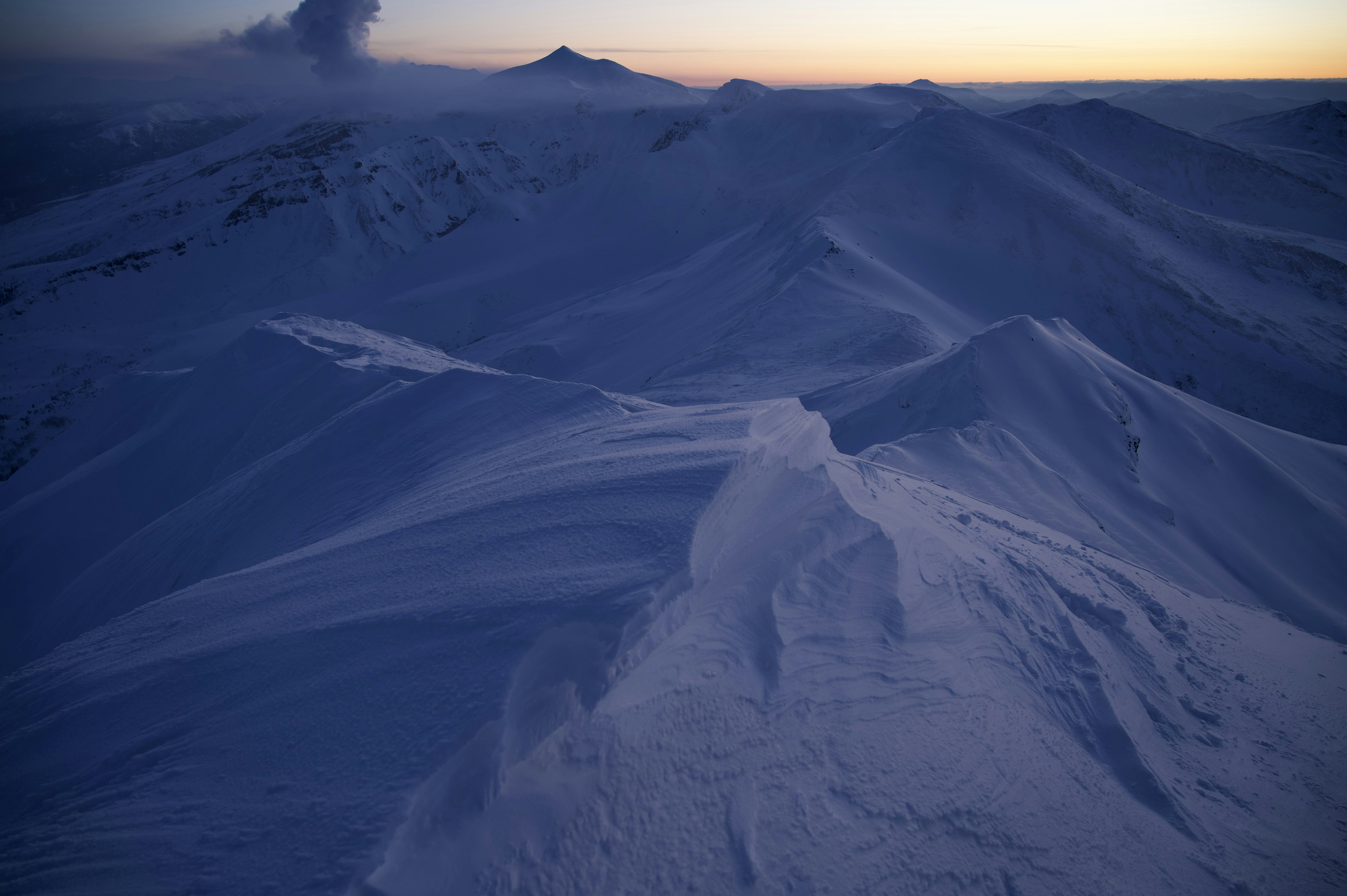 Hermoso paisaje de montañas cubiertas de nieve con luz del atardecer