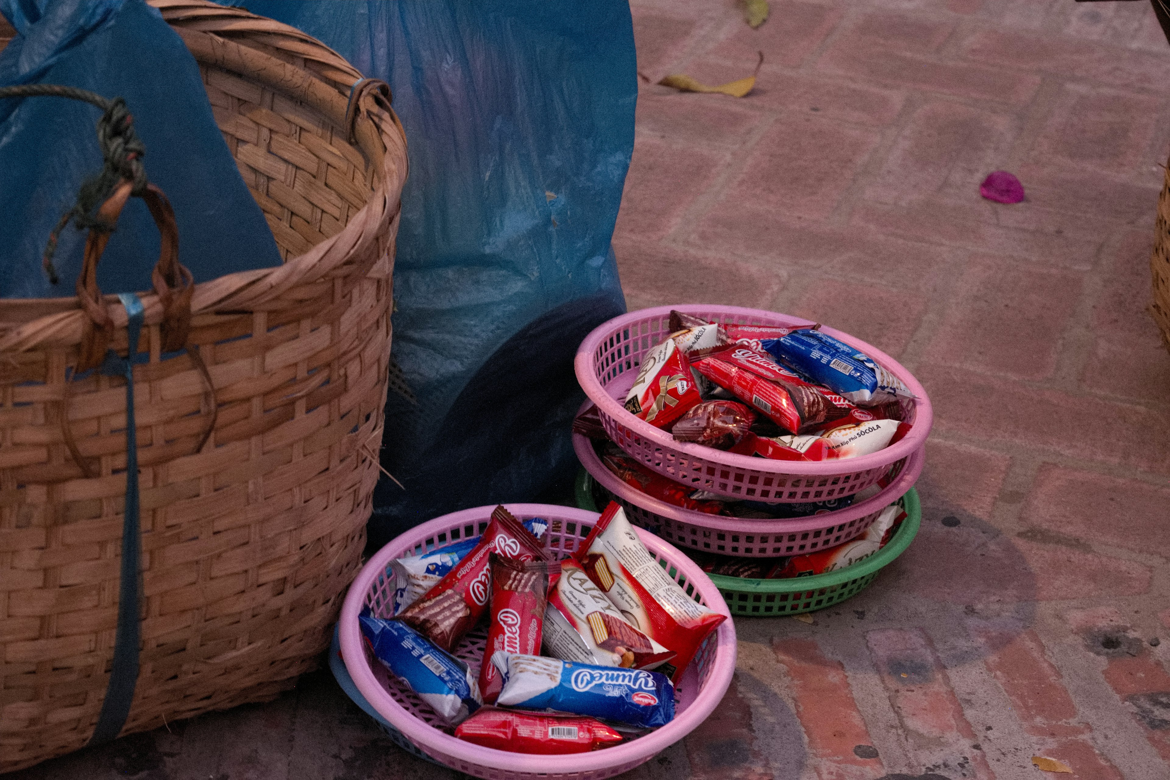 Keranjang berwarna dan piring penuh camilan di lingkungan pasar