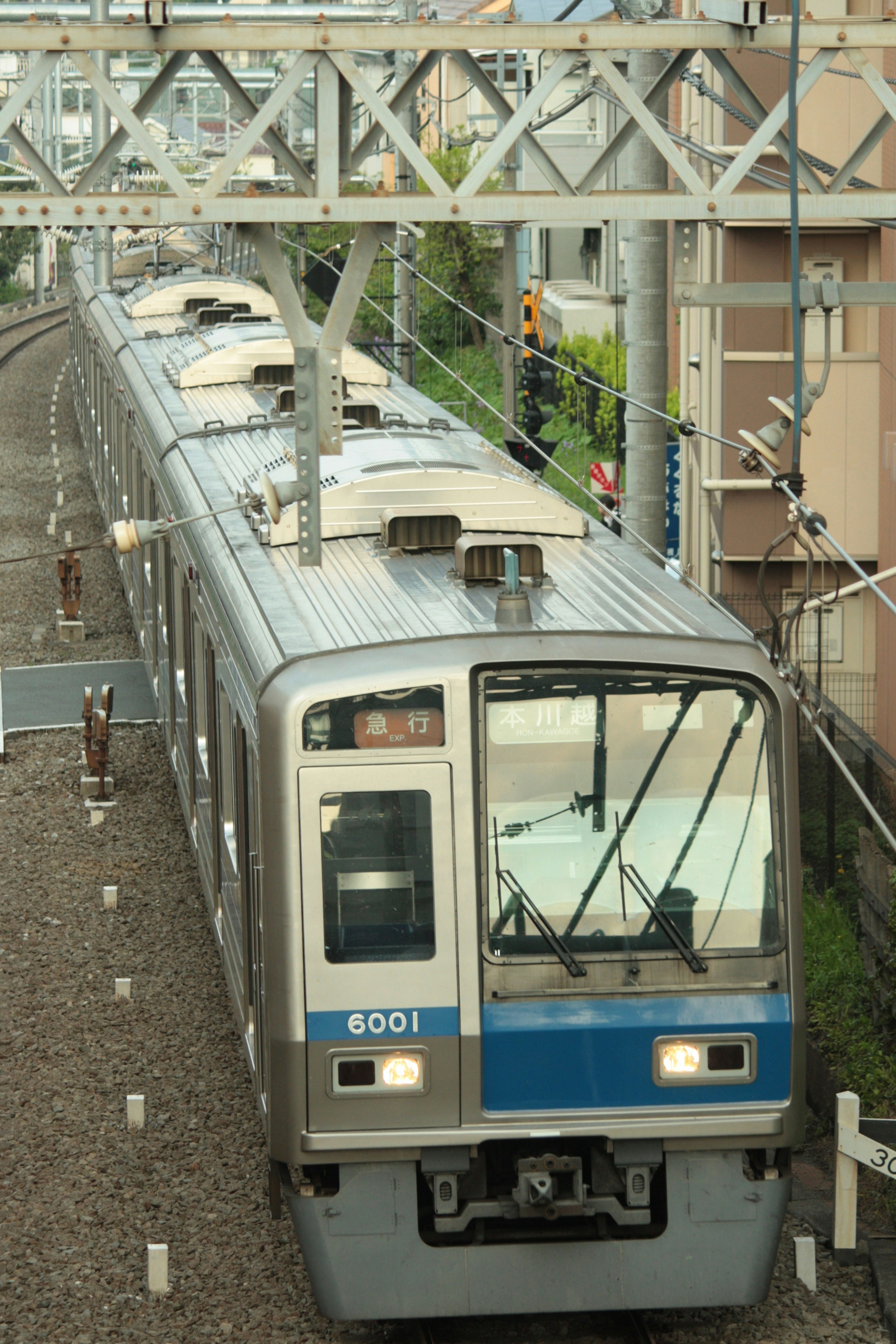 帶藍色條紋的火車在軌道上駛向車站