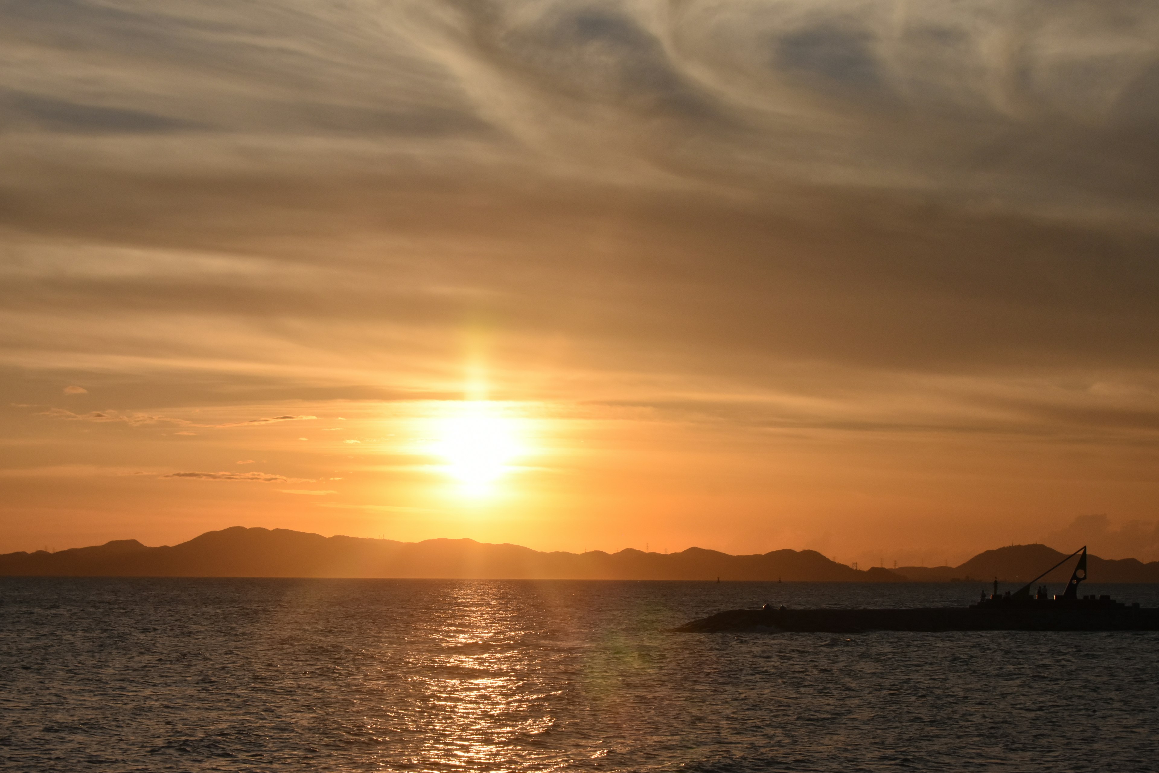 Bellissimo tramonto sull'oceano con onde dolci e montagne sullo sfondo