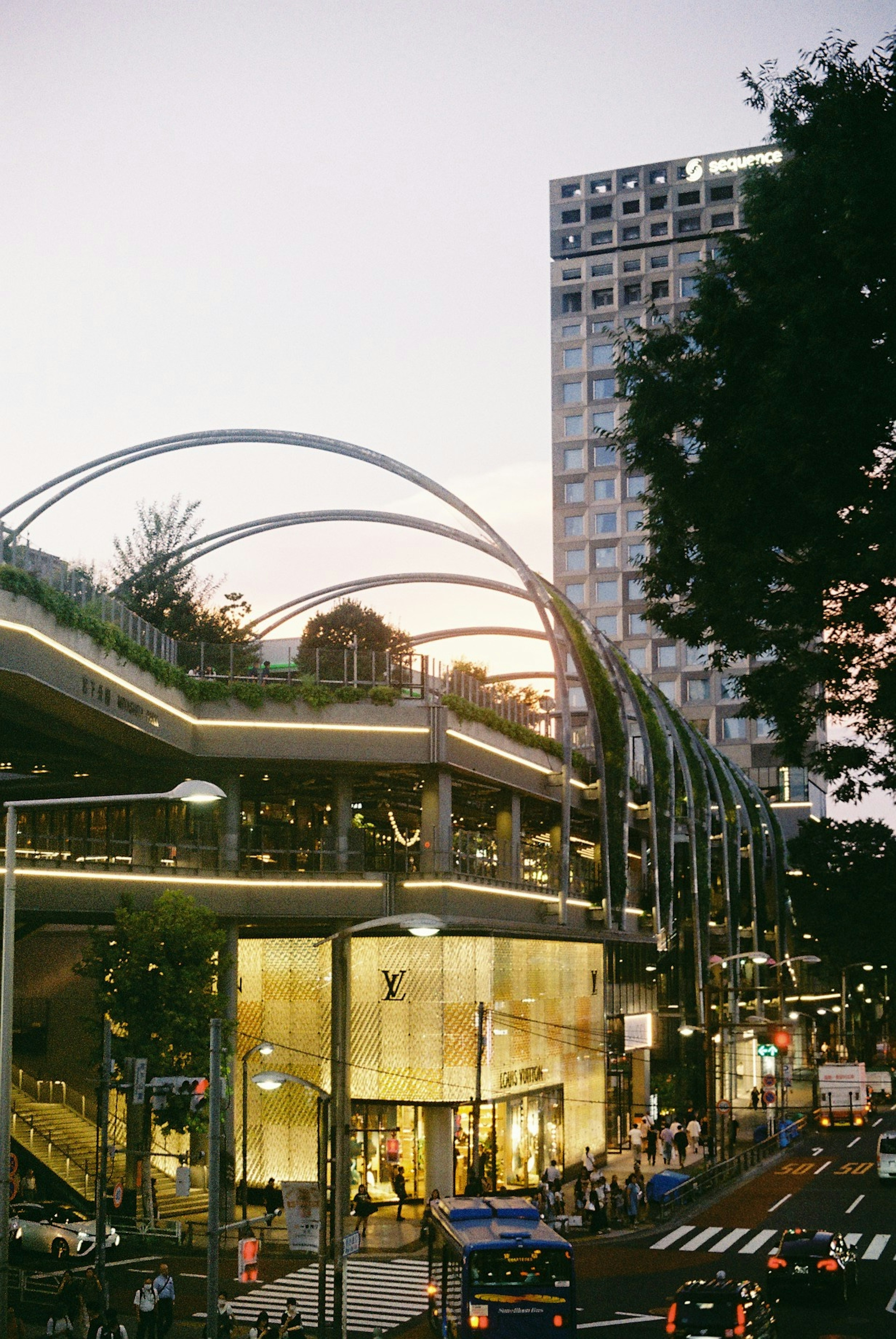 夕暮れ時の都市の風景にある現代的な建物と緑豊かな屋上庭園