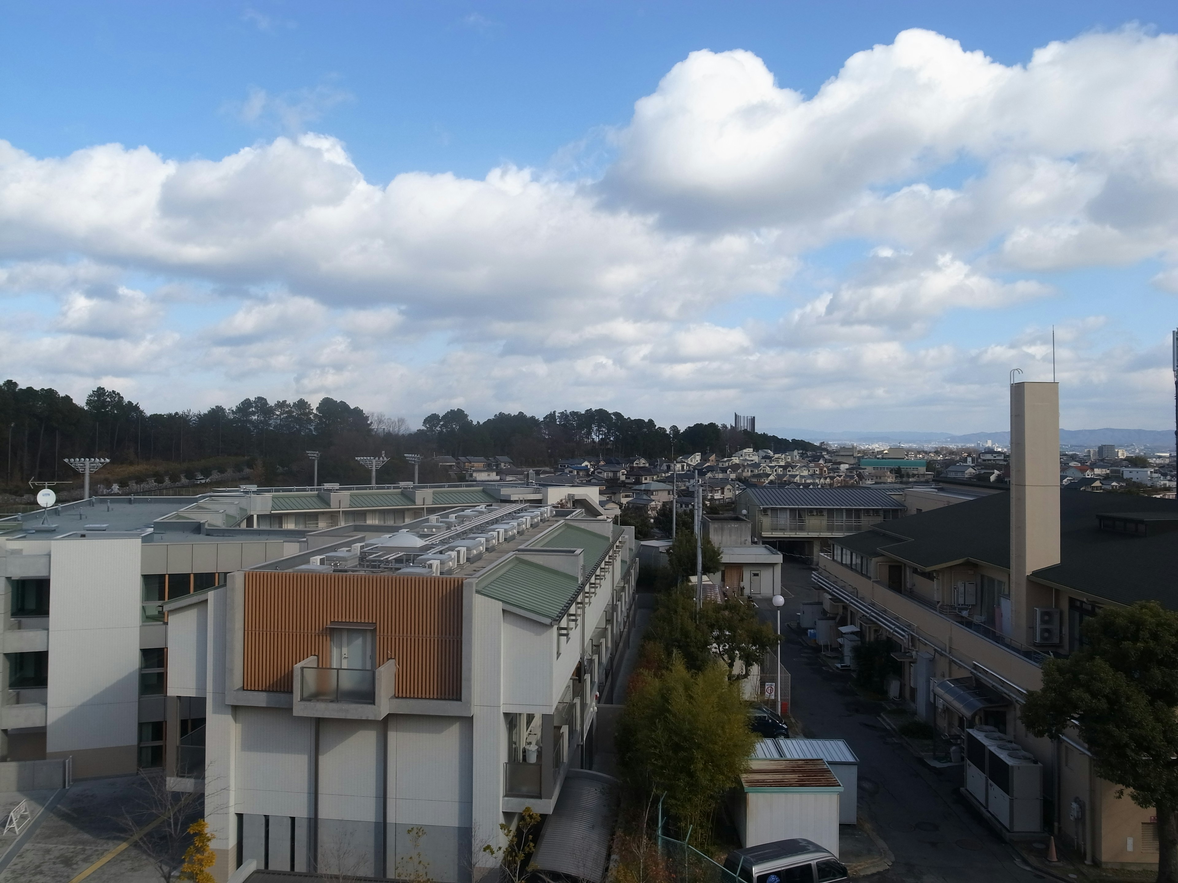 Paesaggio urbano con edifici sotto un cielo blu e nuvole bianche