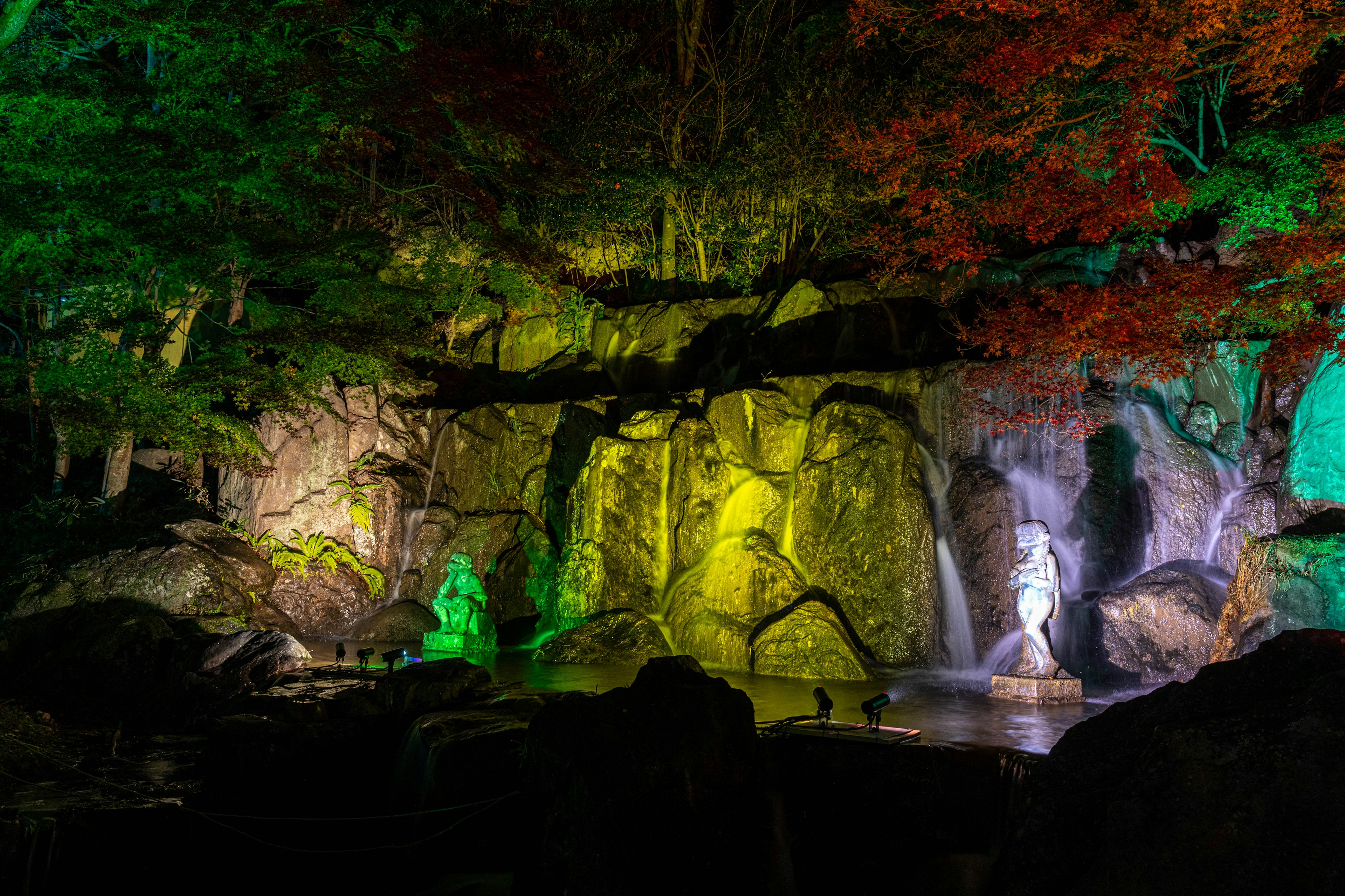 美しい滝と紅葉の景色にカラフルな照明が施された風景