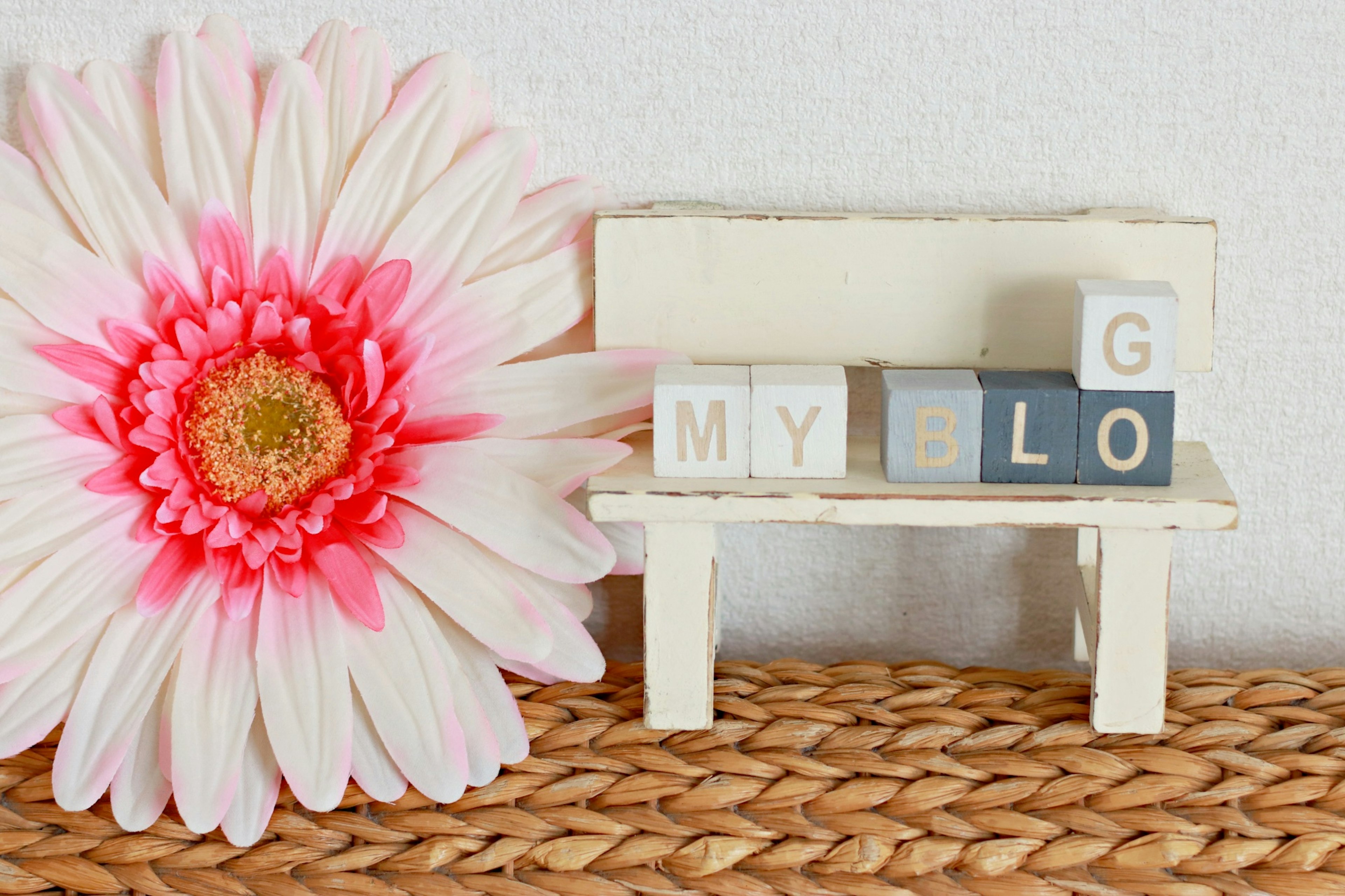 Colorful blocks on a white bench with a large pink flower