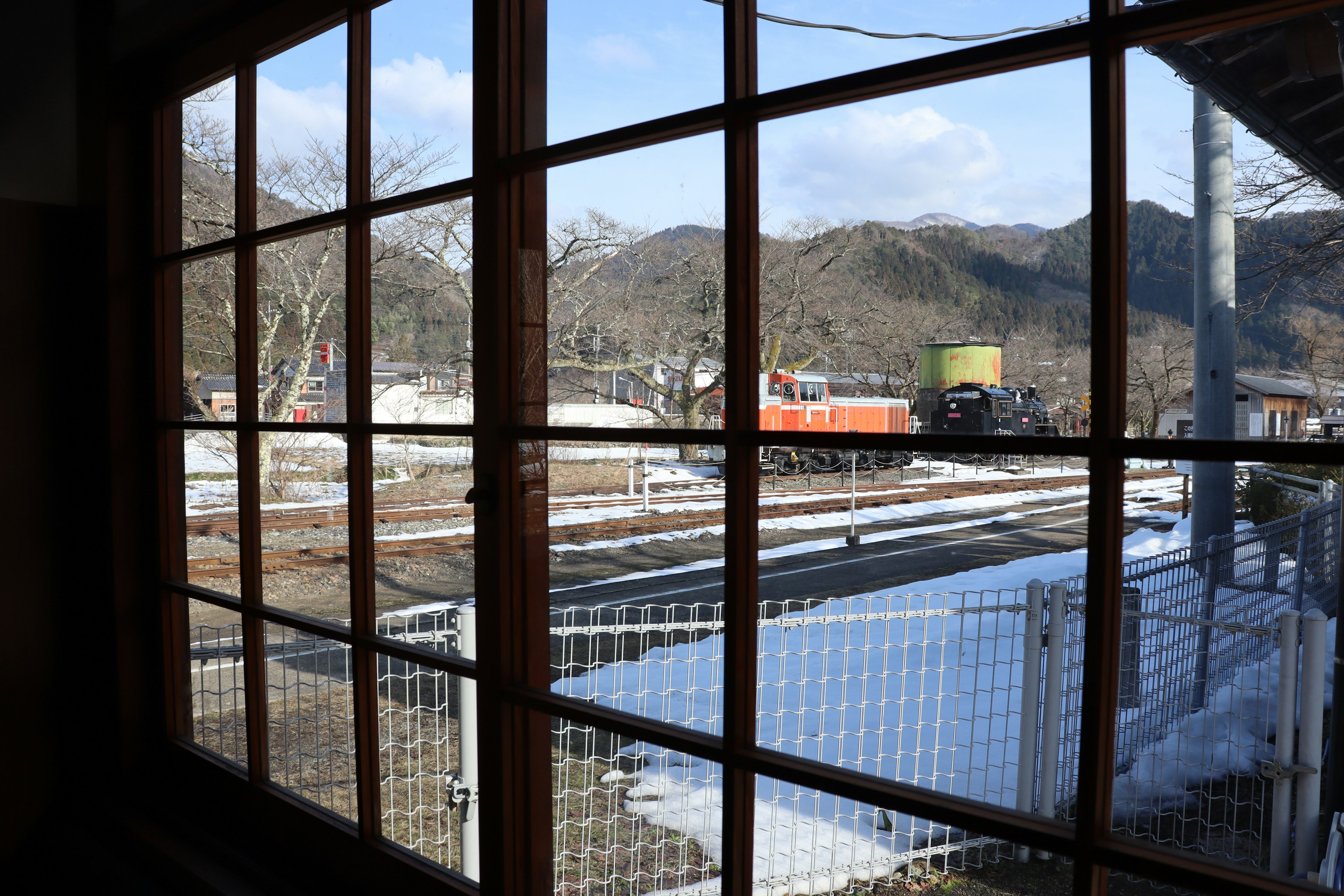 View from a window showing a snowy landscape and mountains