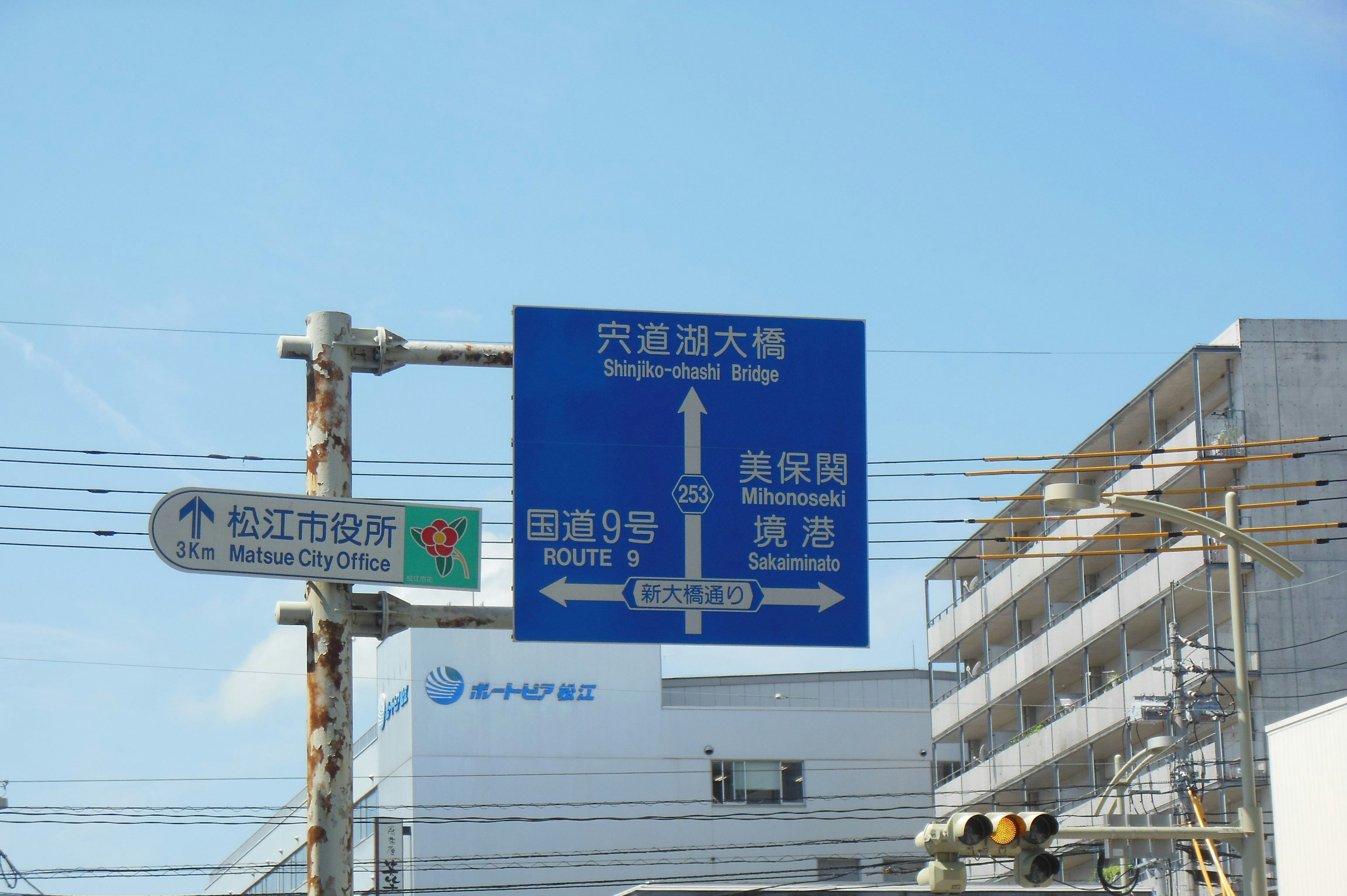 Blue traffic sign displaying directions and distances