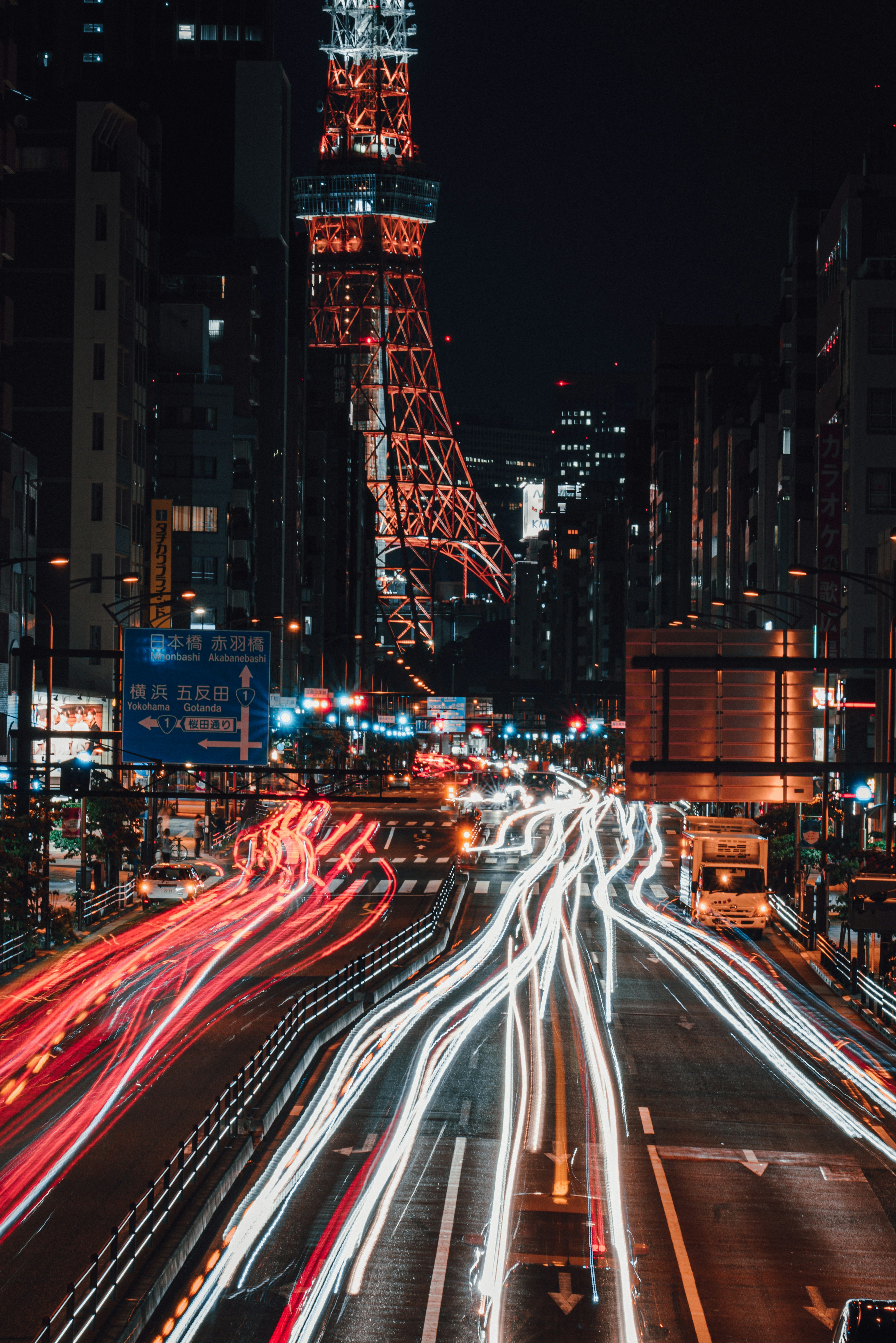 Vista notturna della Tokyo Tower con luci di auto in movimento