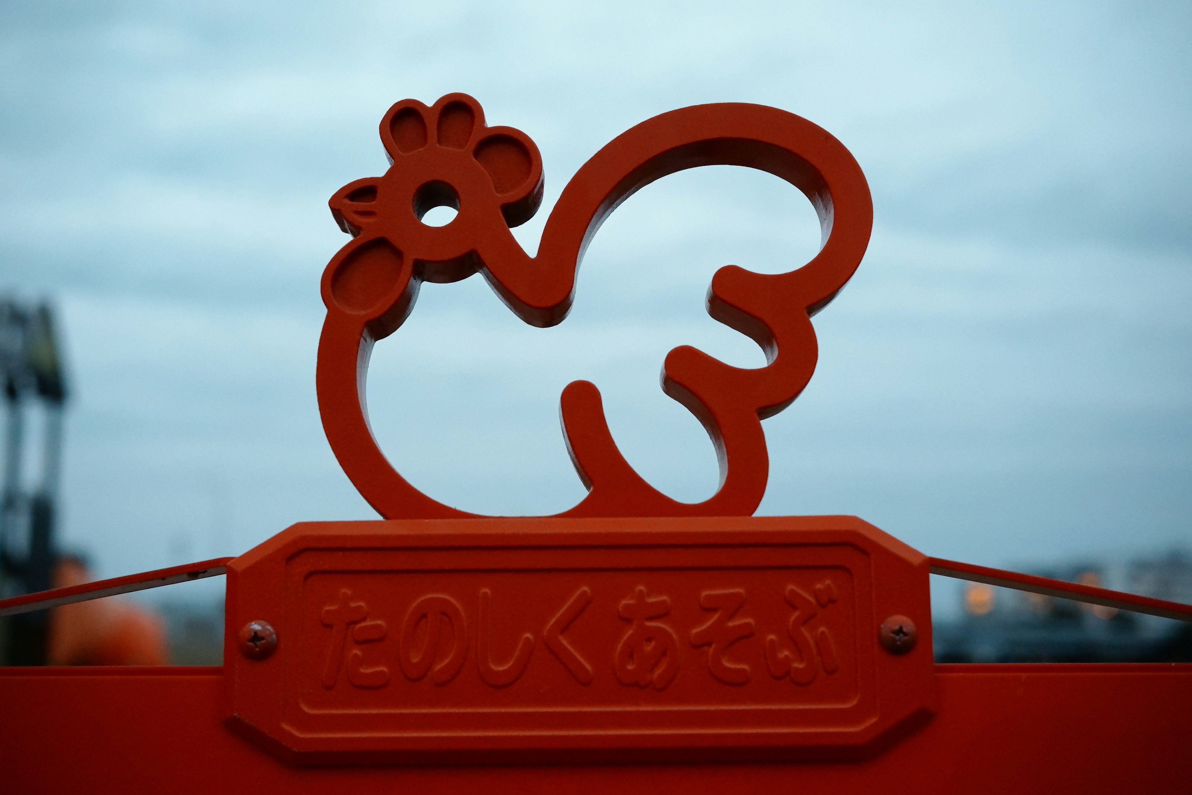 A striking red silhouette of a chicken on a sign