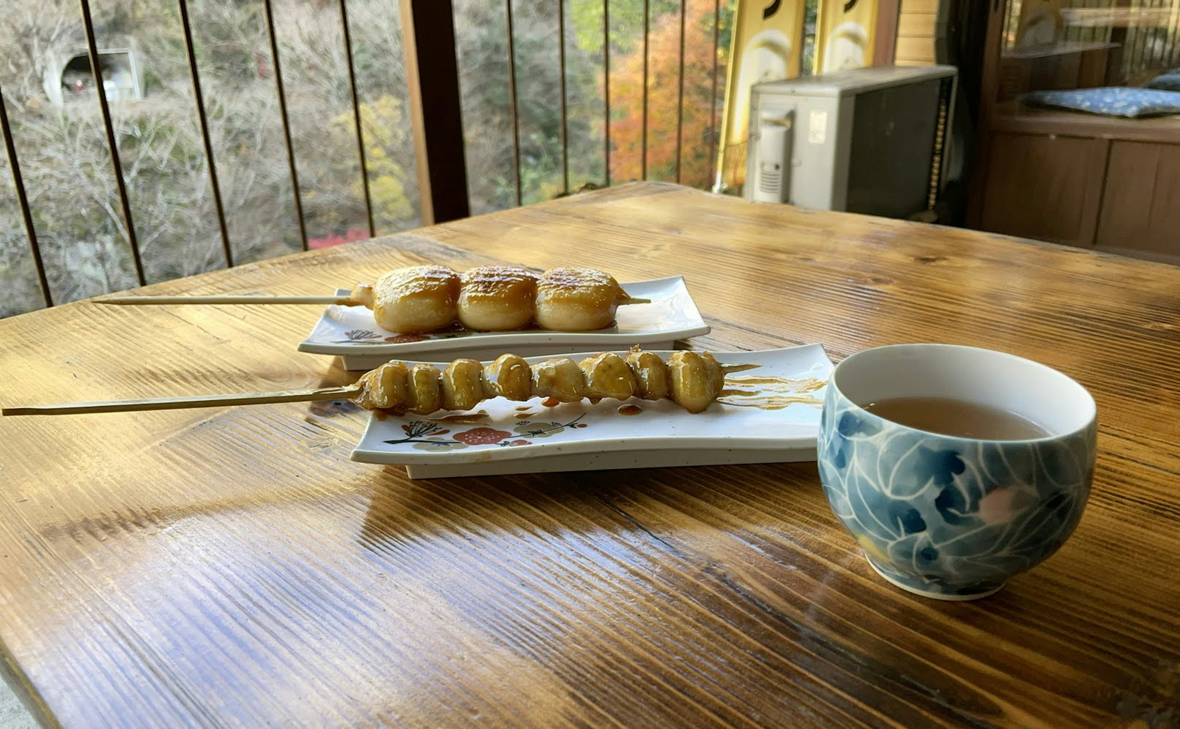 A wooden table with traditional Japanese sweets and a cup of tea