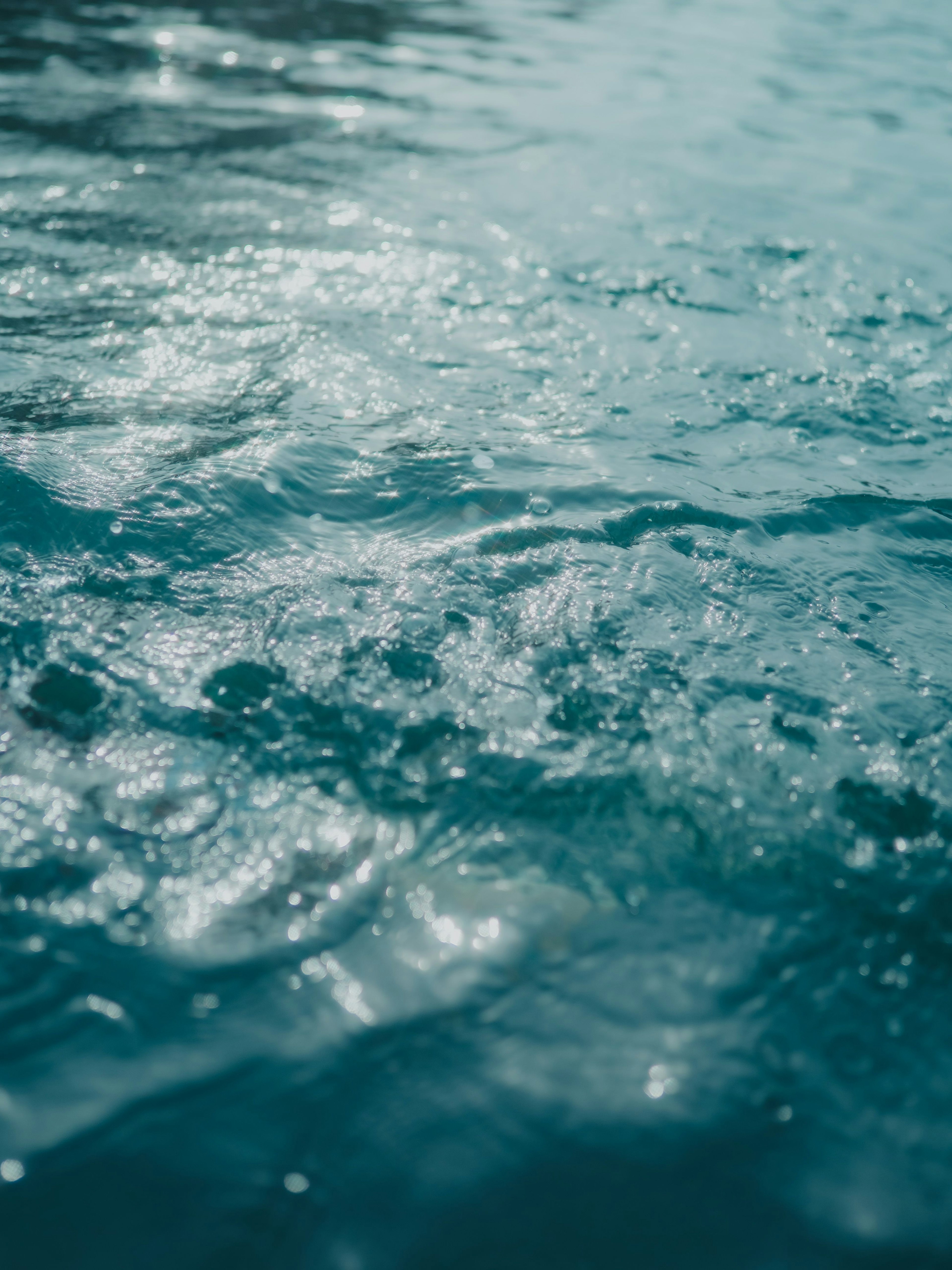 Superficie d'acqua ondulata con riflessi scintillanti in tonalità blu