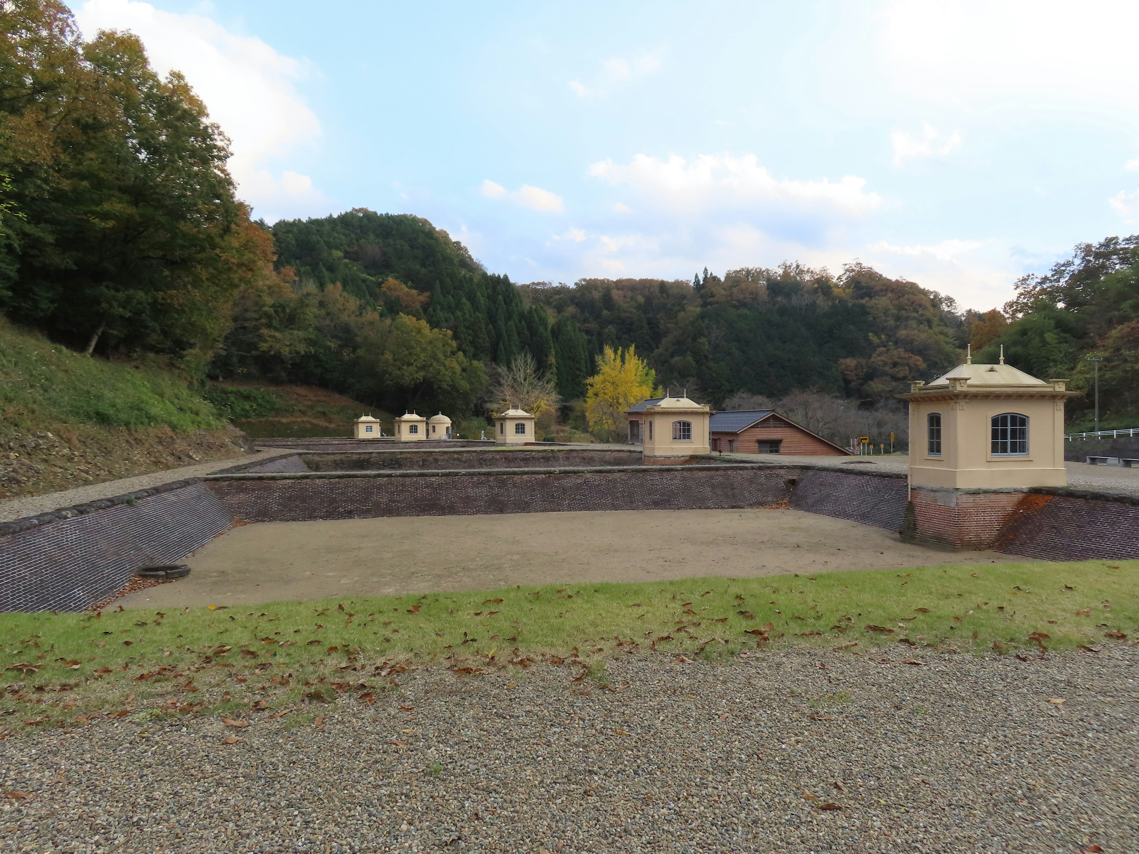 A serene landscape featuring small buildings surrounded by green grass